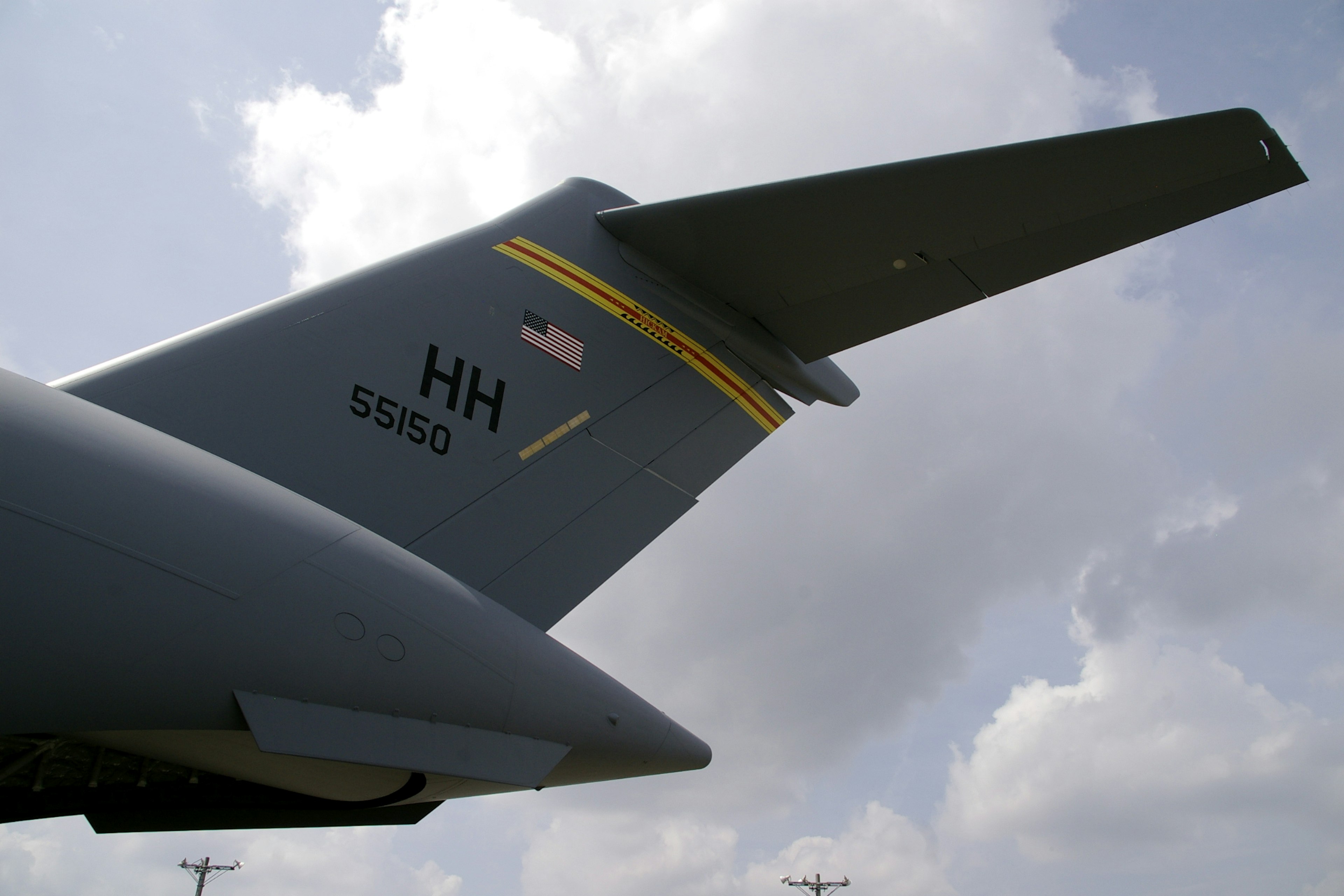 Close-up of a military aircraft tail featuring a flag and identification code