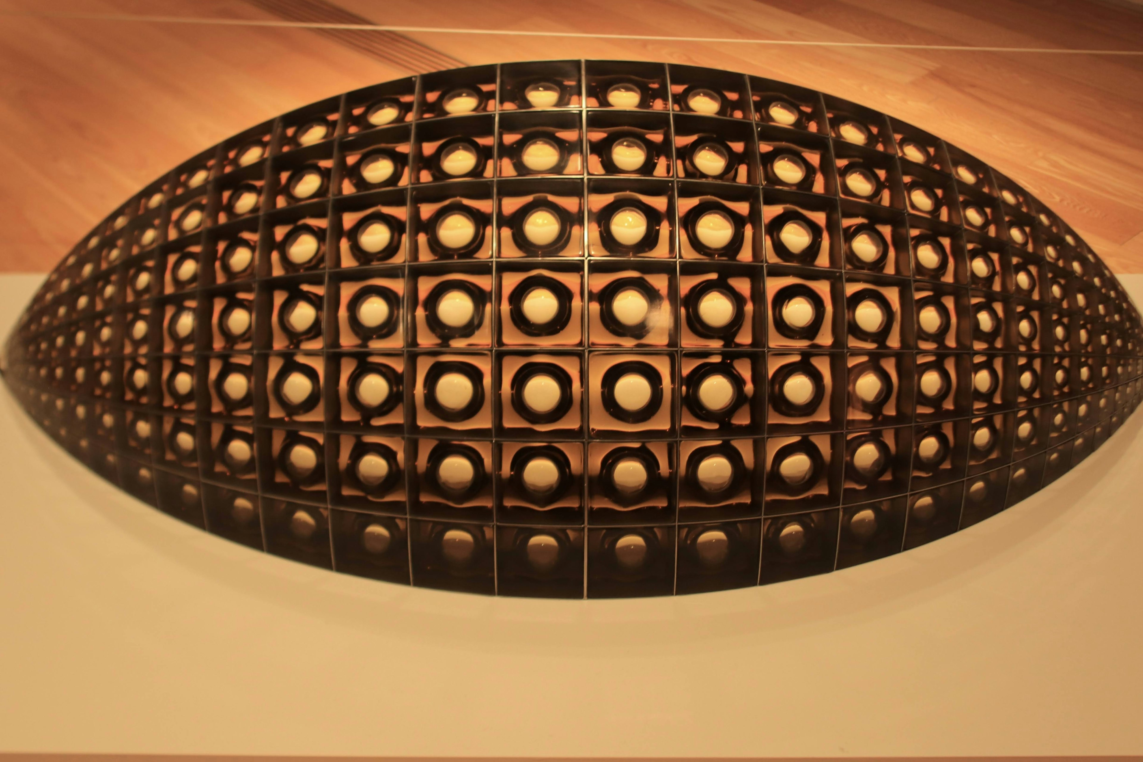 Wooden sculpture featuring a lattice design in an oval shape