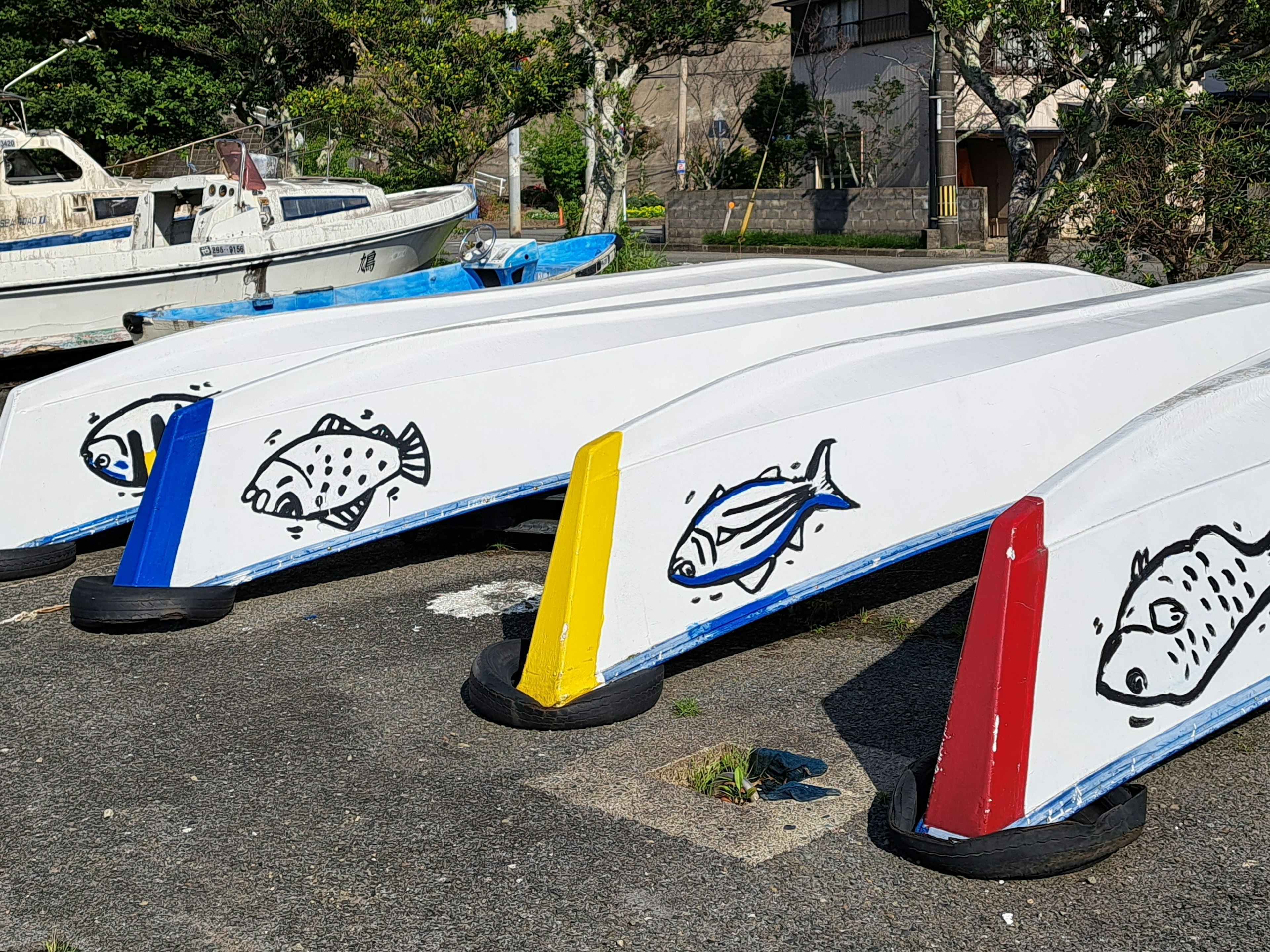 Cascos de barco coloridos con ilustraciones de peces