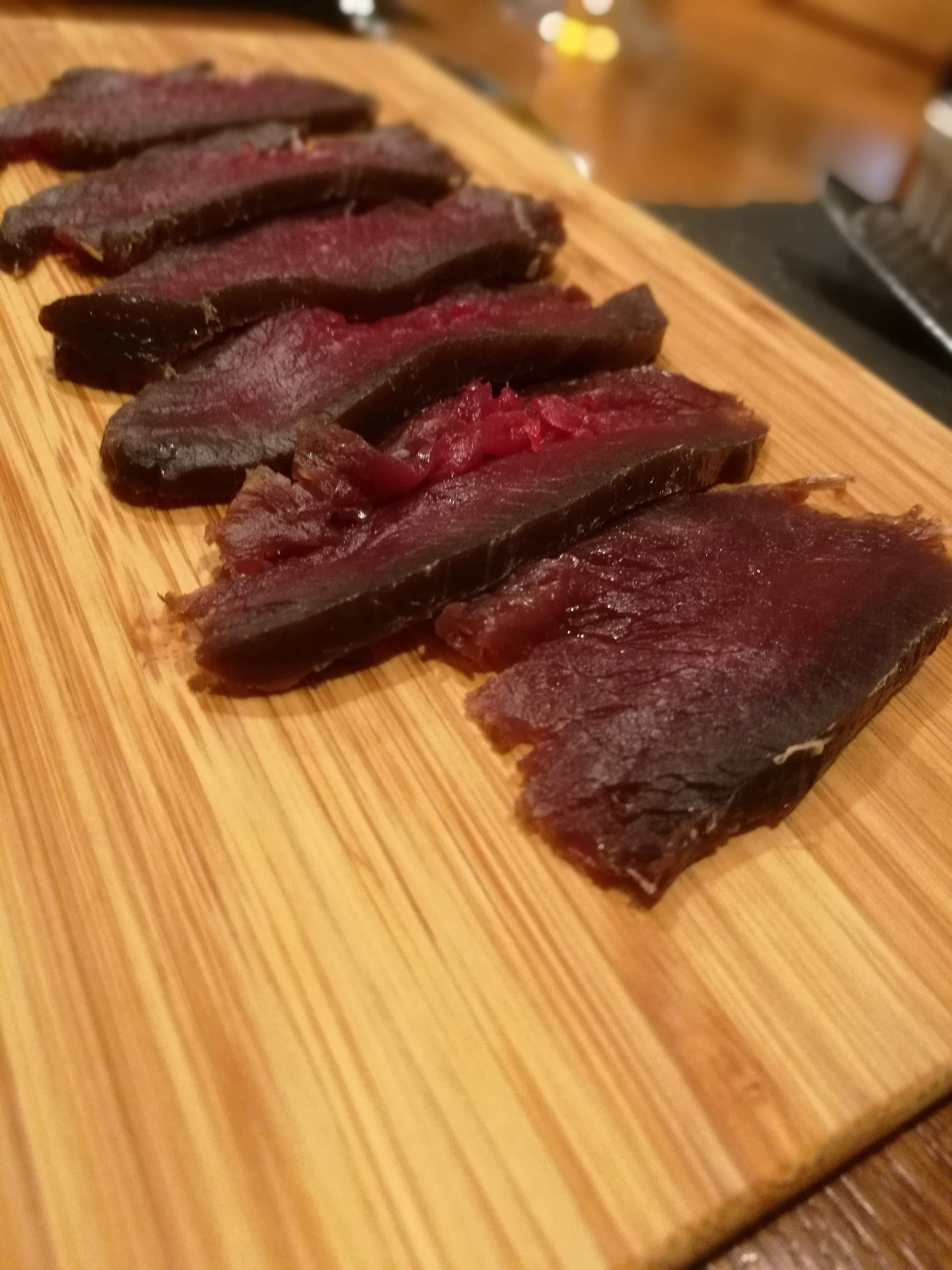 Sliced jerky arranged on a wooden board