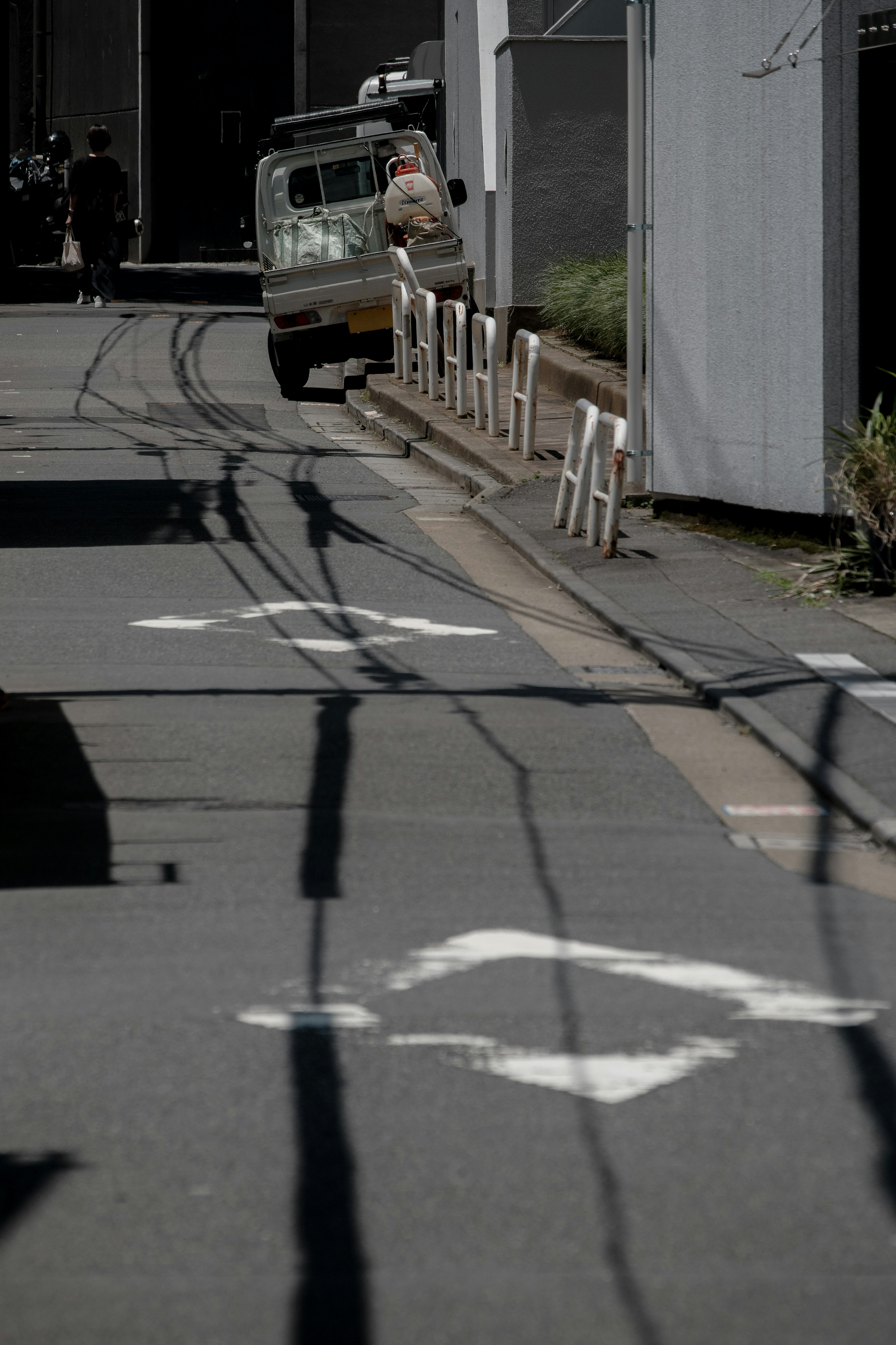 Rue étroite avec un véhicule garé et des ombres