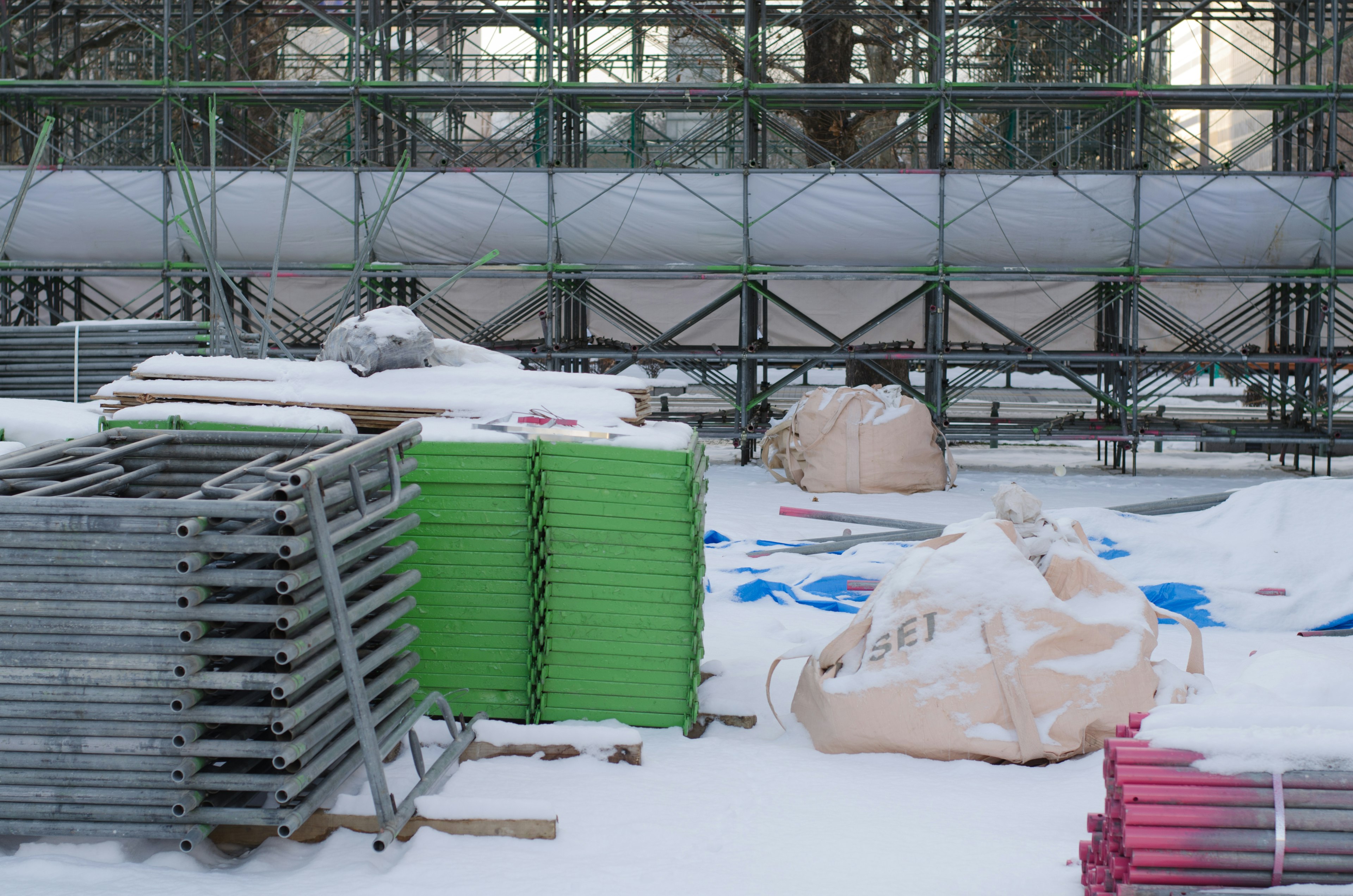 Construction site materials and scaffolding covered in snow