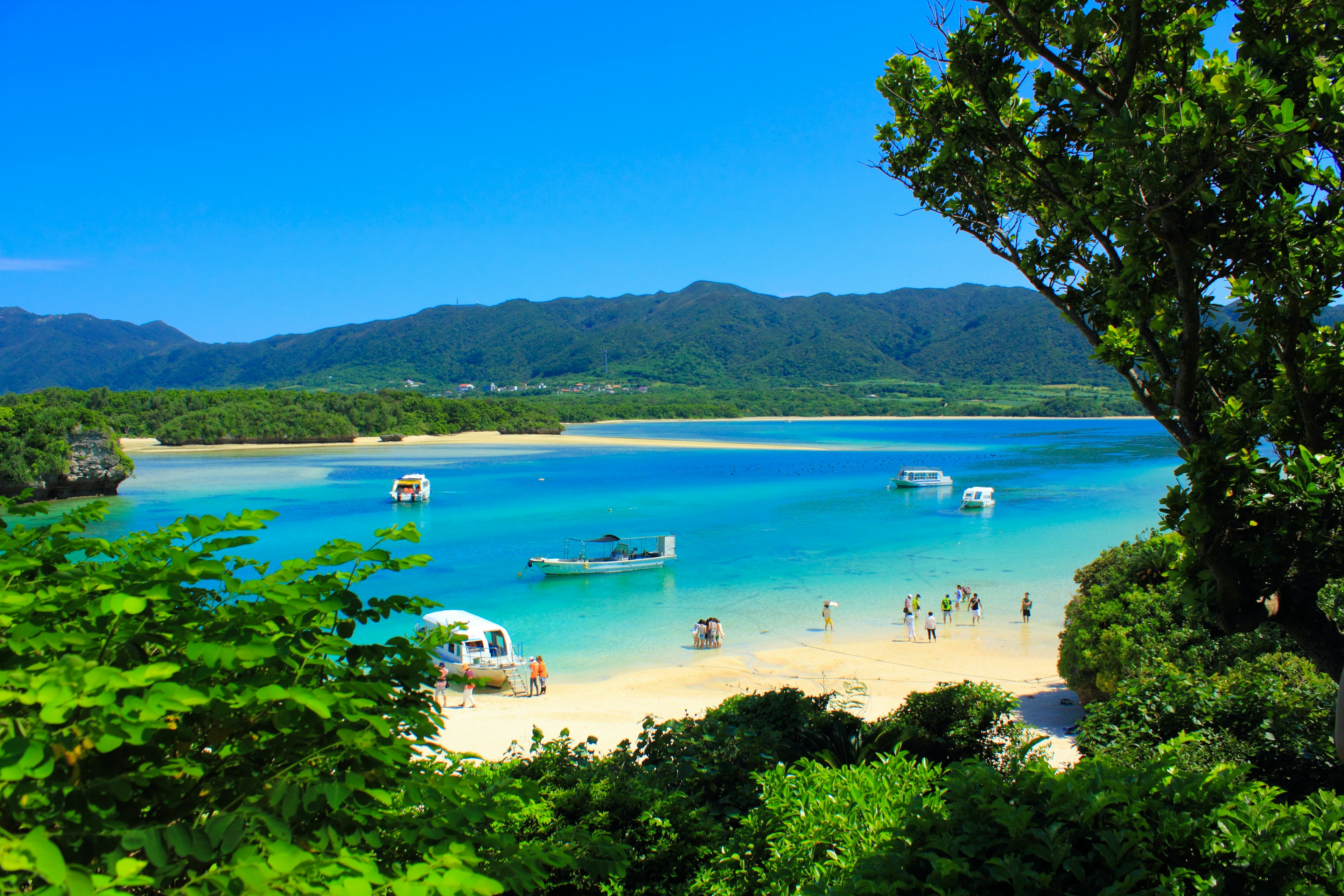 ทิวทัศน์ของชายหาดที่มีน้ำทะเลสีฟ้าใสและทรายขาว