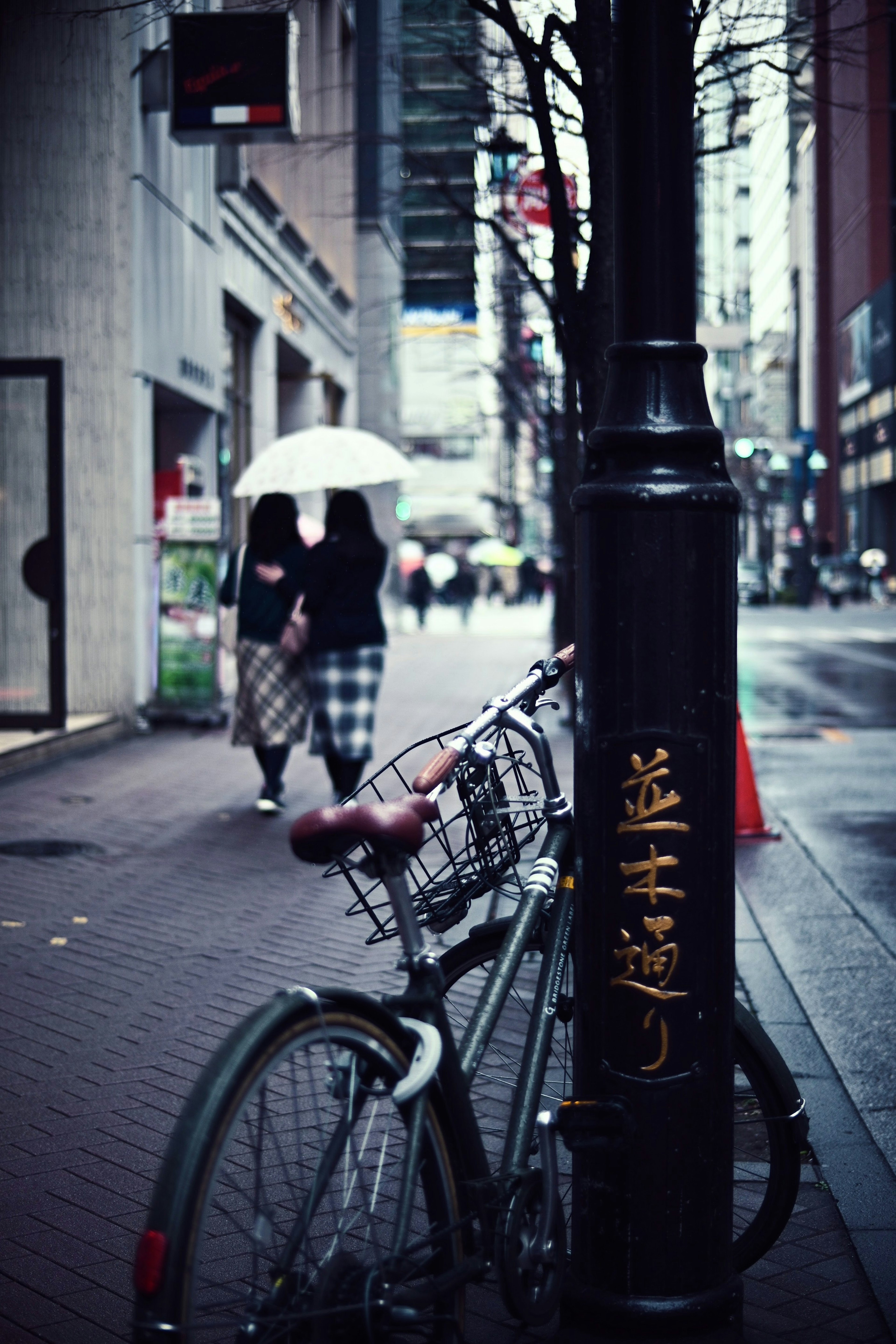 街の中にある自転車と傘を持った人々が歩いている風景