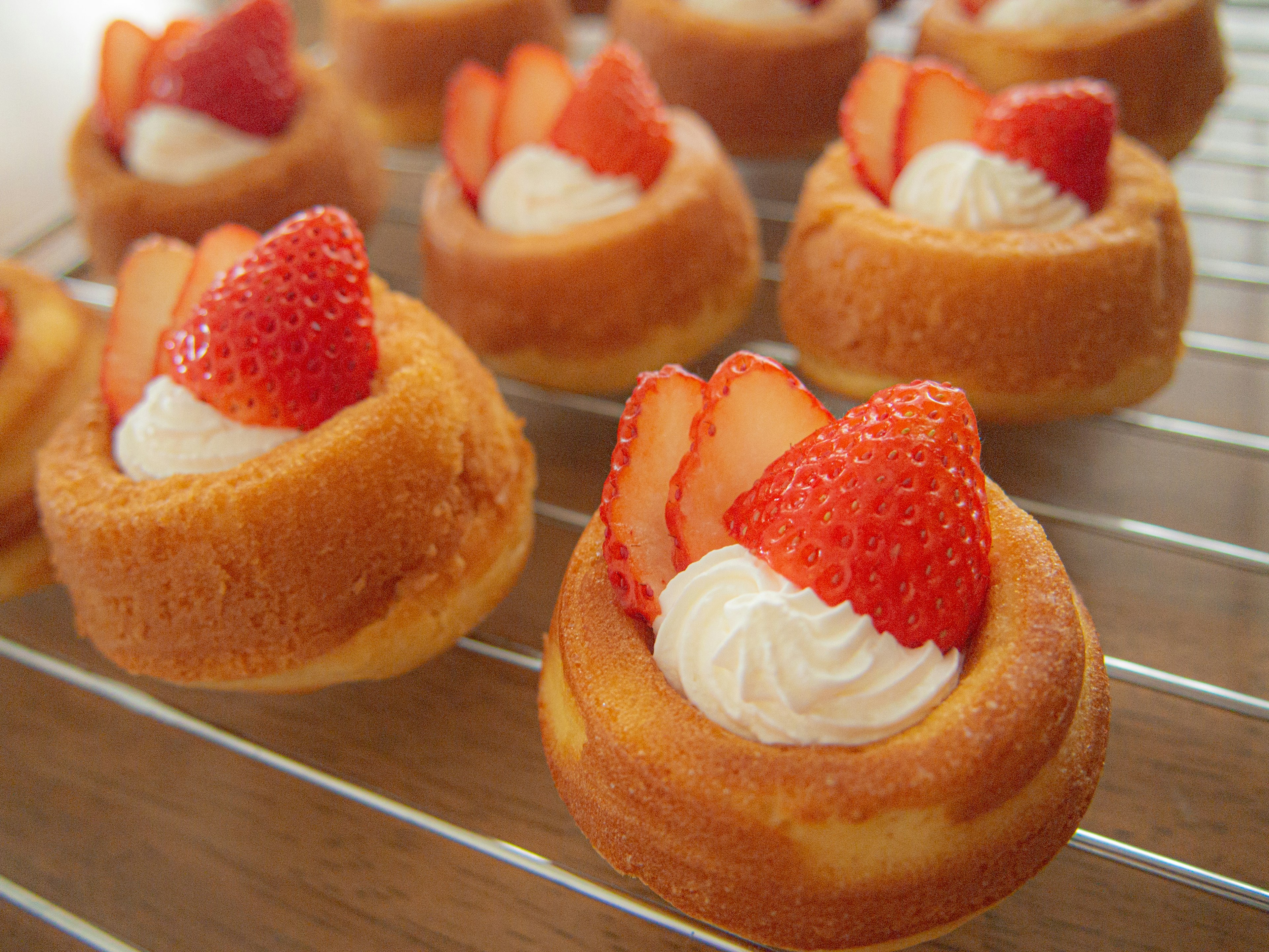 A photo of strawberry tarts topped with cream and fresh strawberries