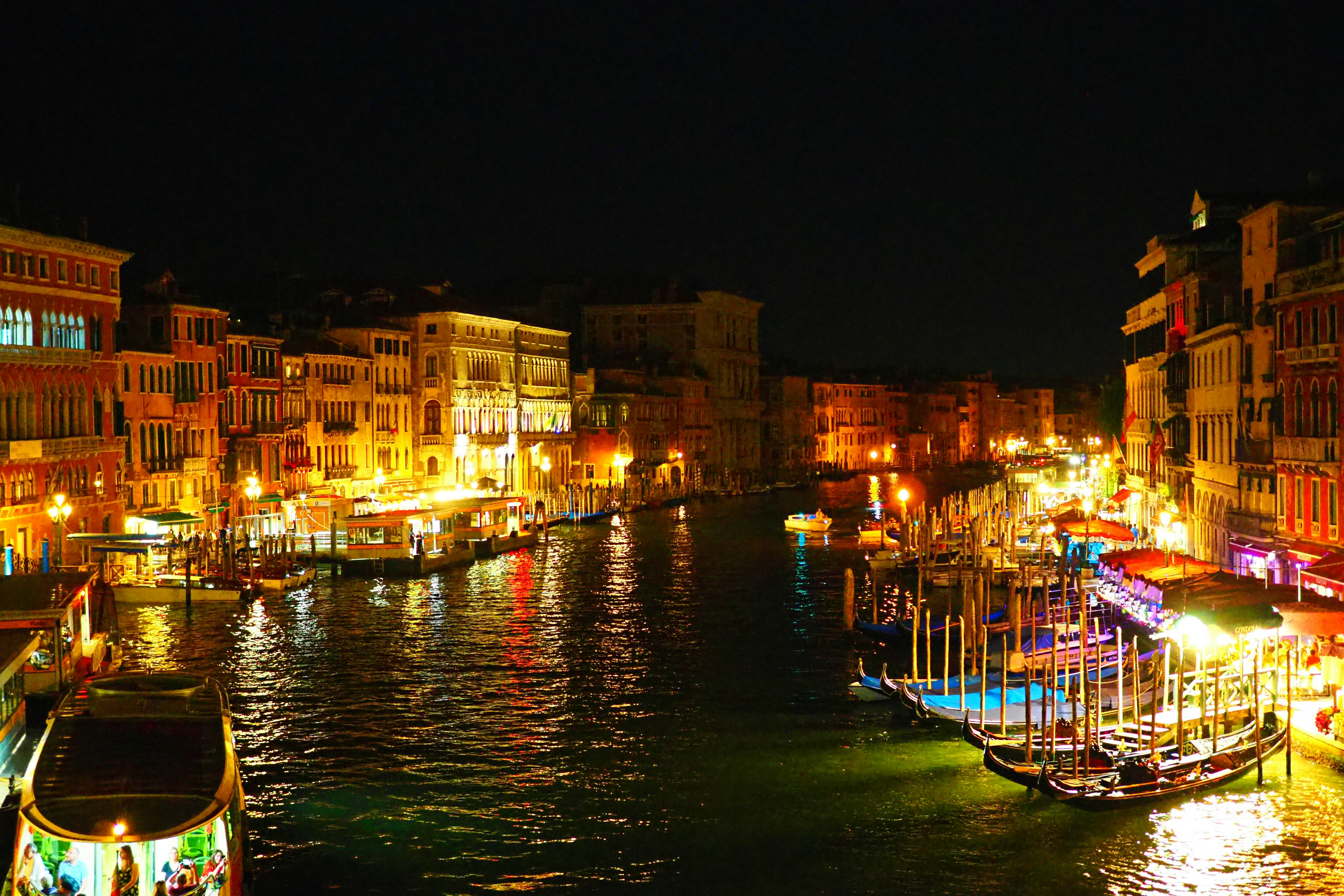 Nachtszene in Venedig mit beleuchteten Kanälen und bunten Booten