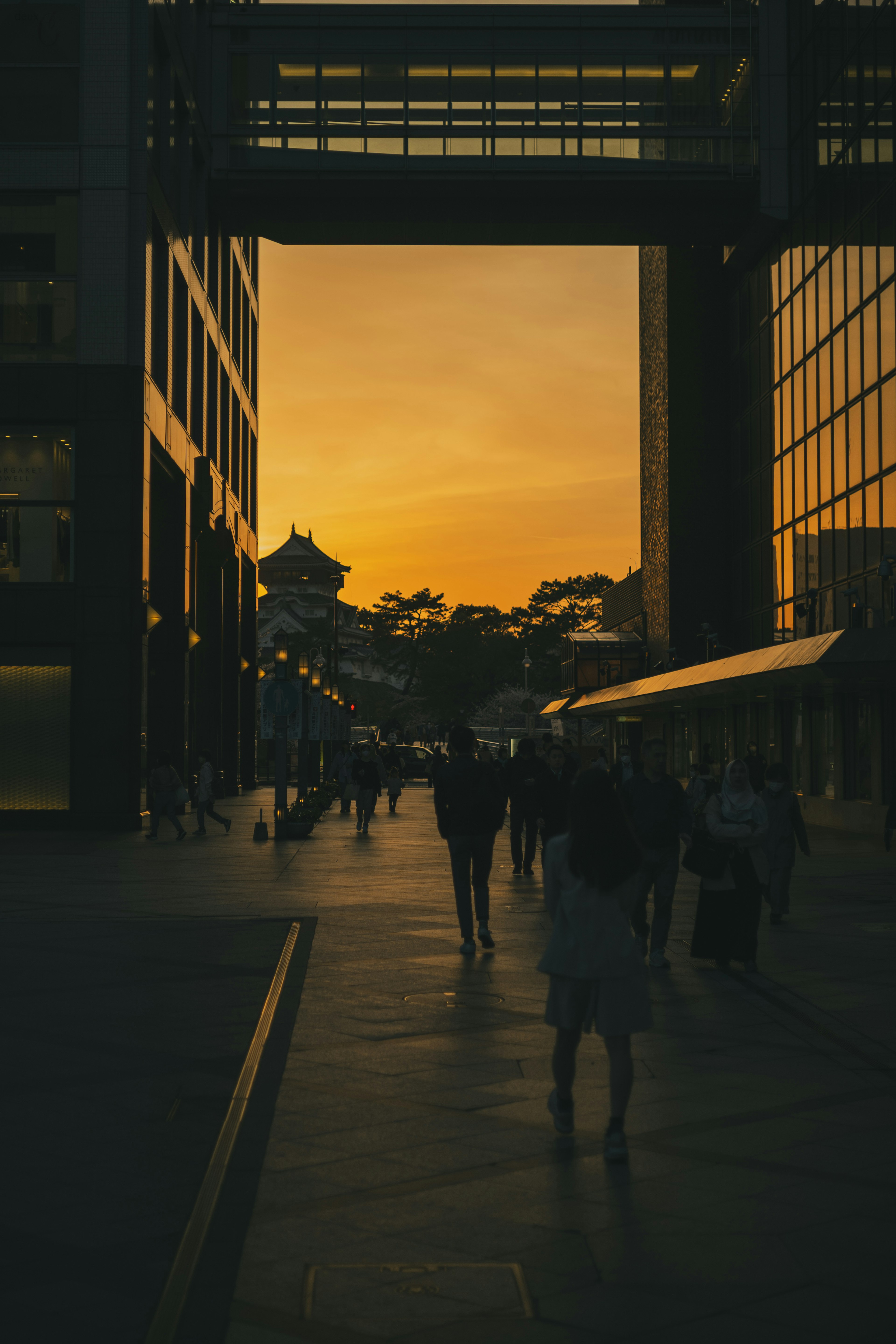 Silhouette d'une ville au coucher du soleil avec des gens marchant