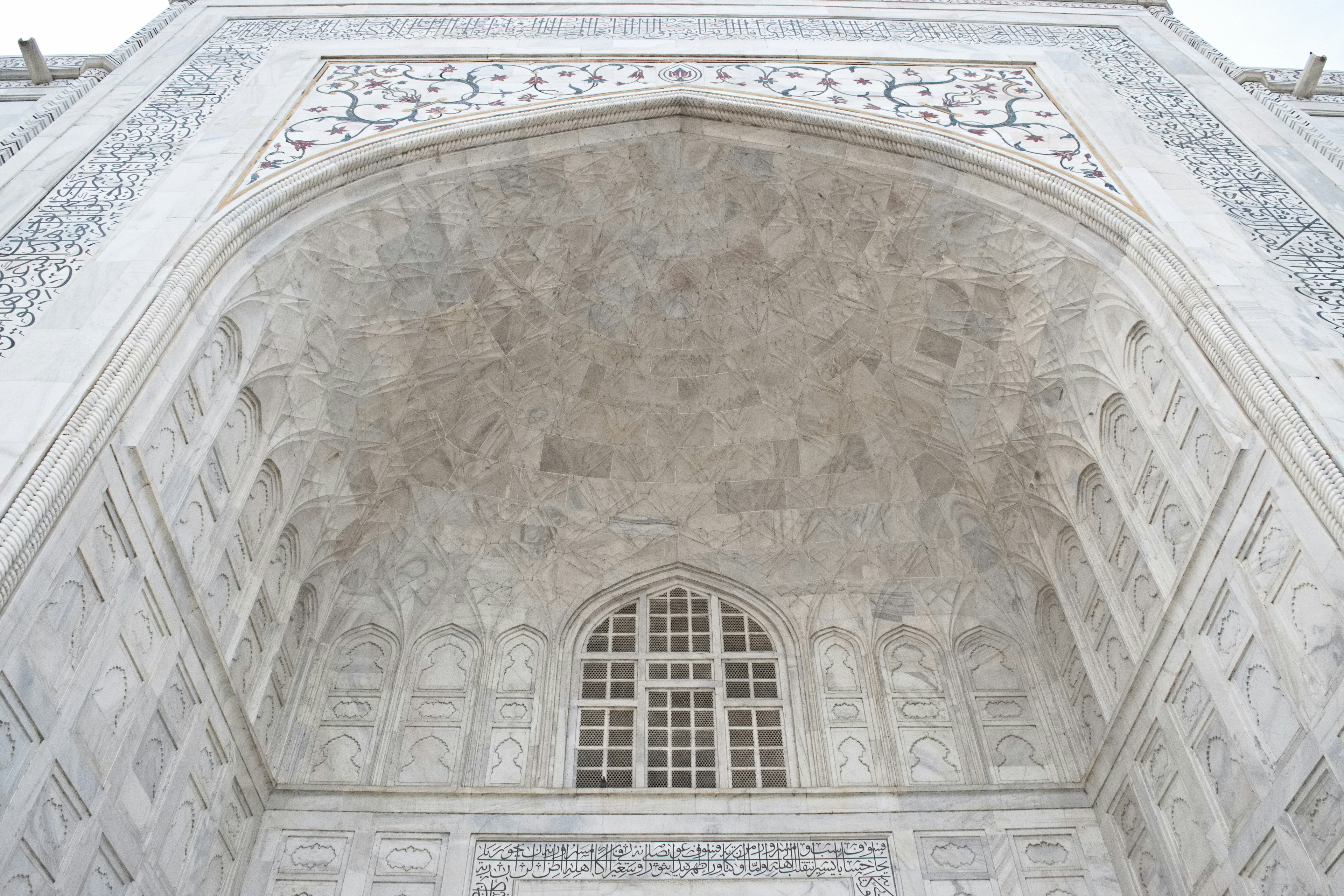 Vista del arco decorado del Taj Mahal mirando hacia arriba