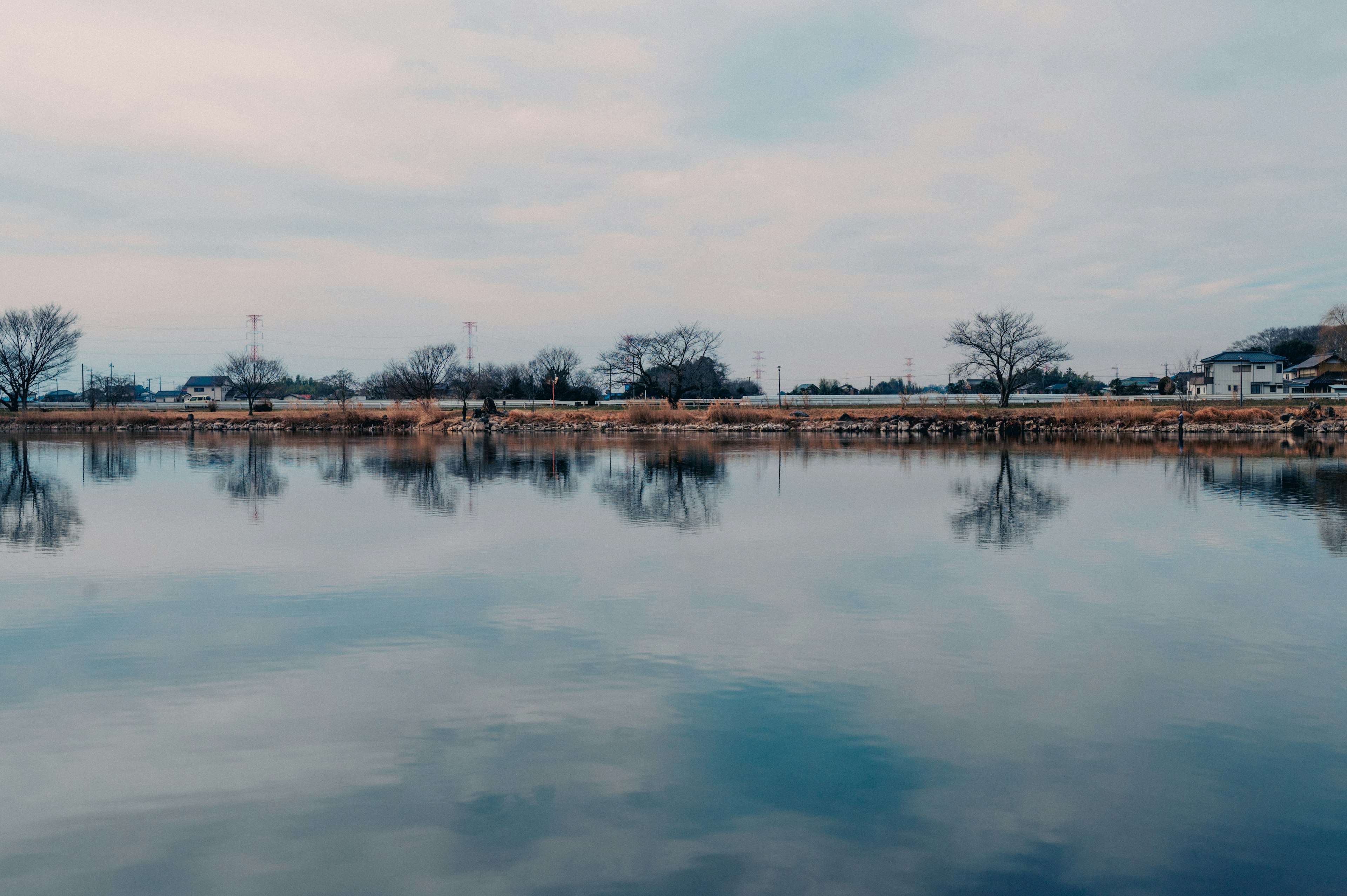 Lago calmo che riflette alberi e cielo