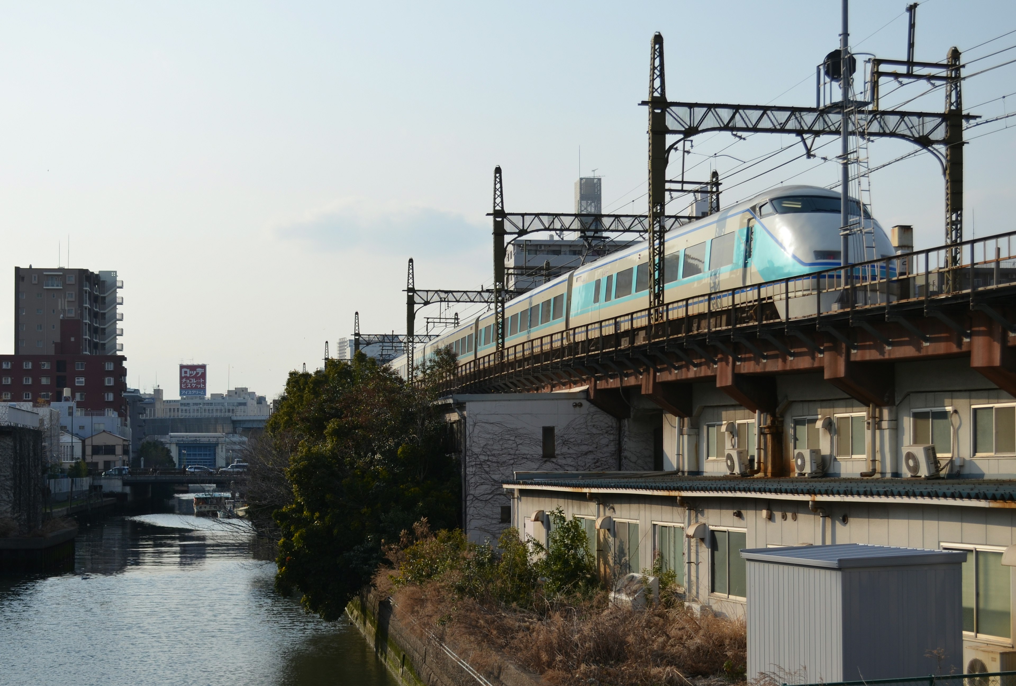 Blue Shinkansen train running over a river