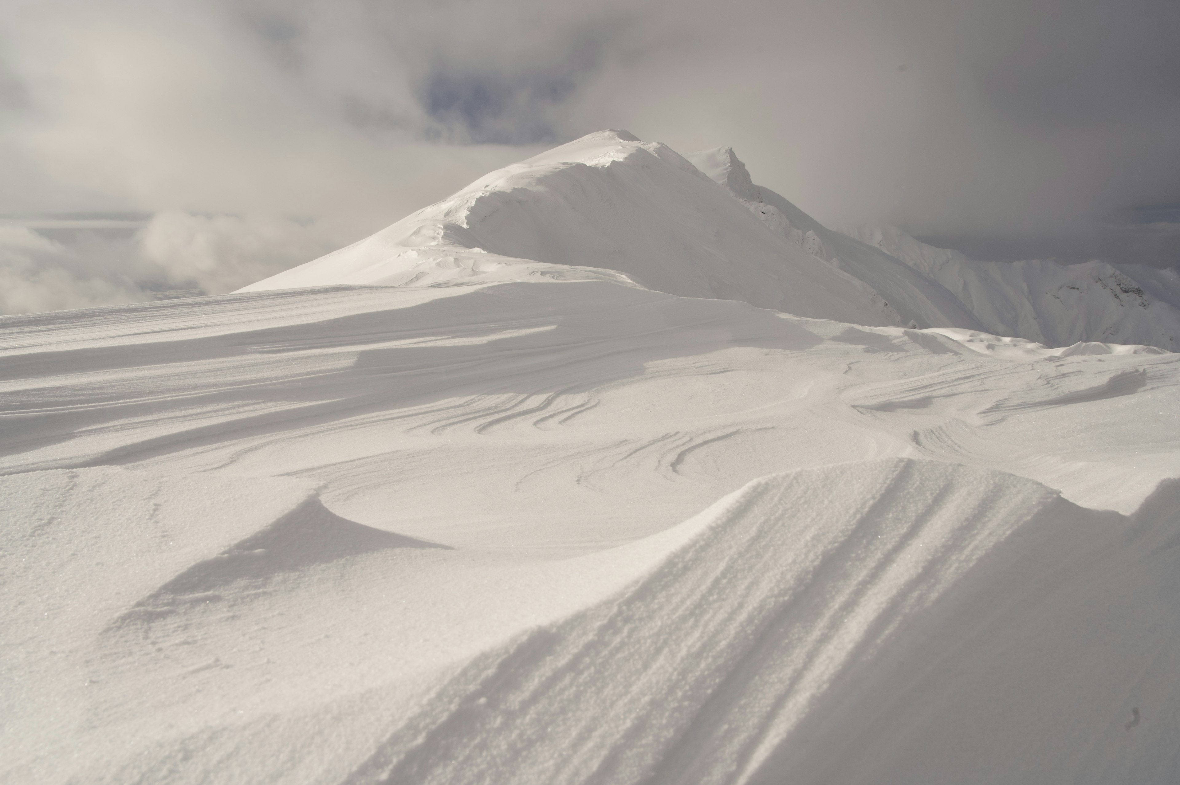 Schneebedeckte Berglandschaft mit sanften Kurven und Wellen