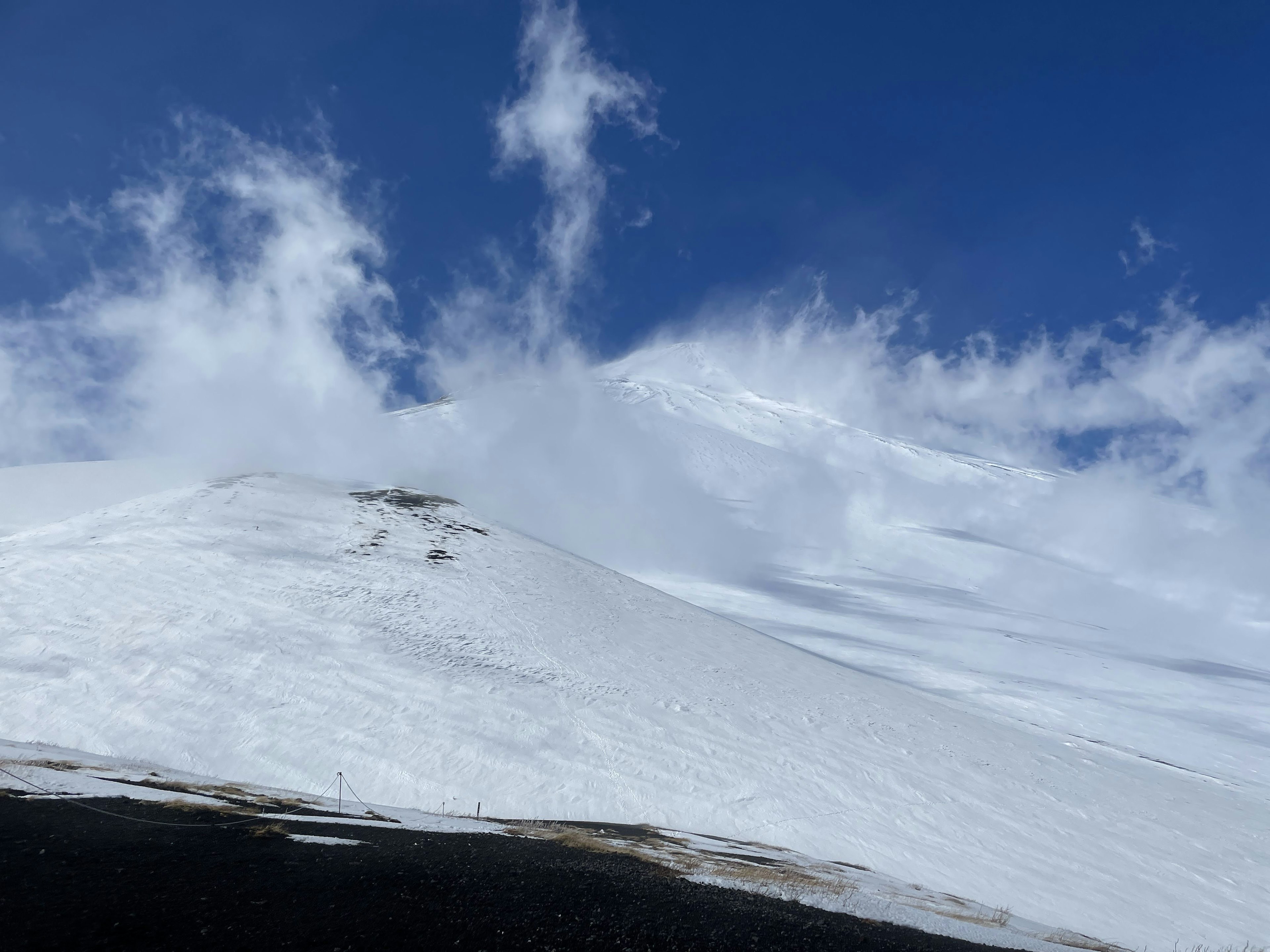 雪に覆われた山の斜面と青い空が広がる風景