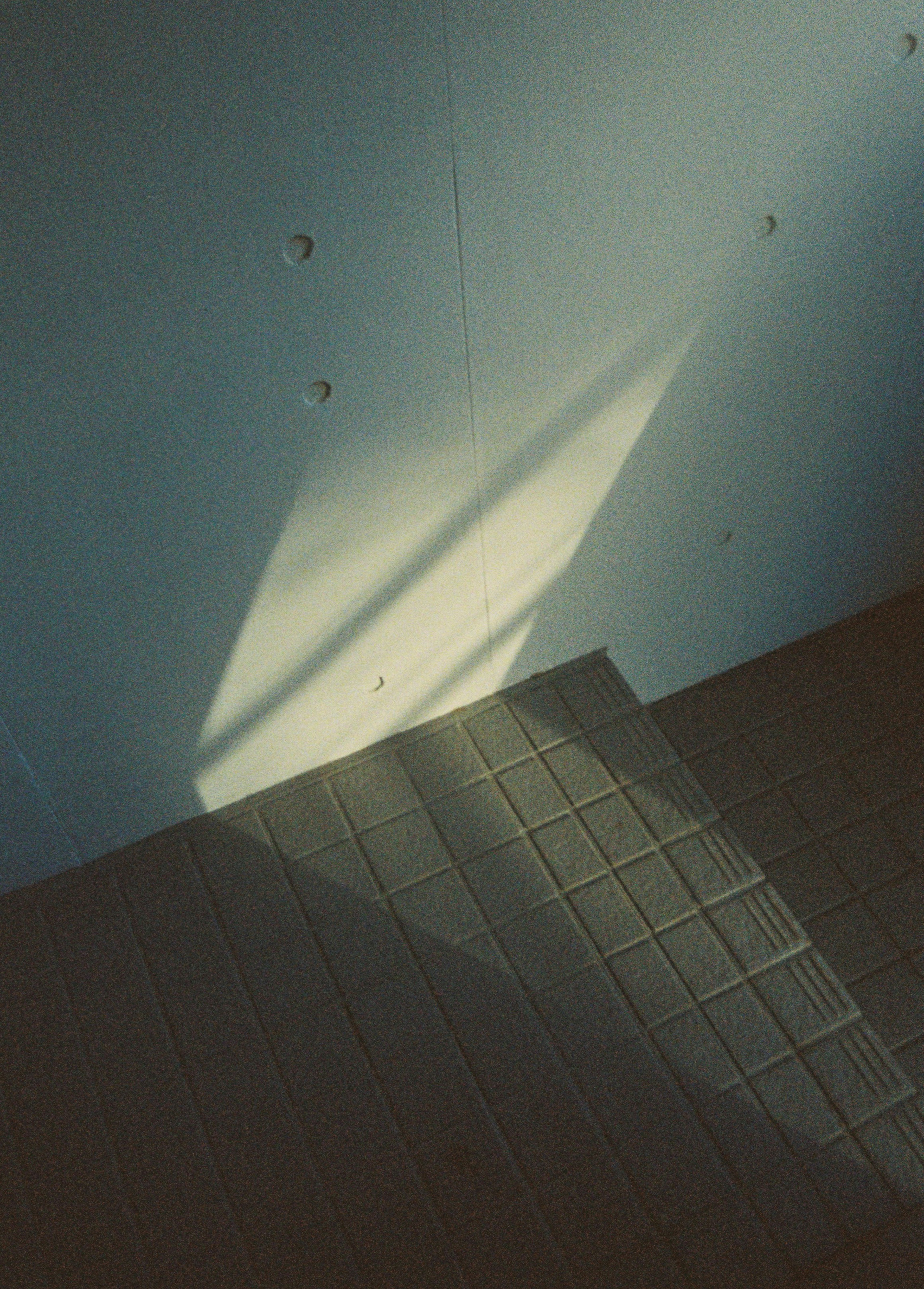 Diagonal light casting a shadow on a textured floor