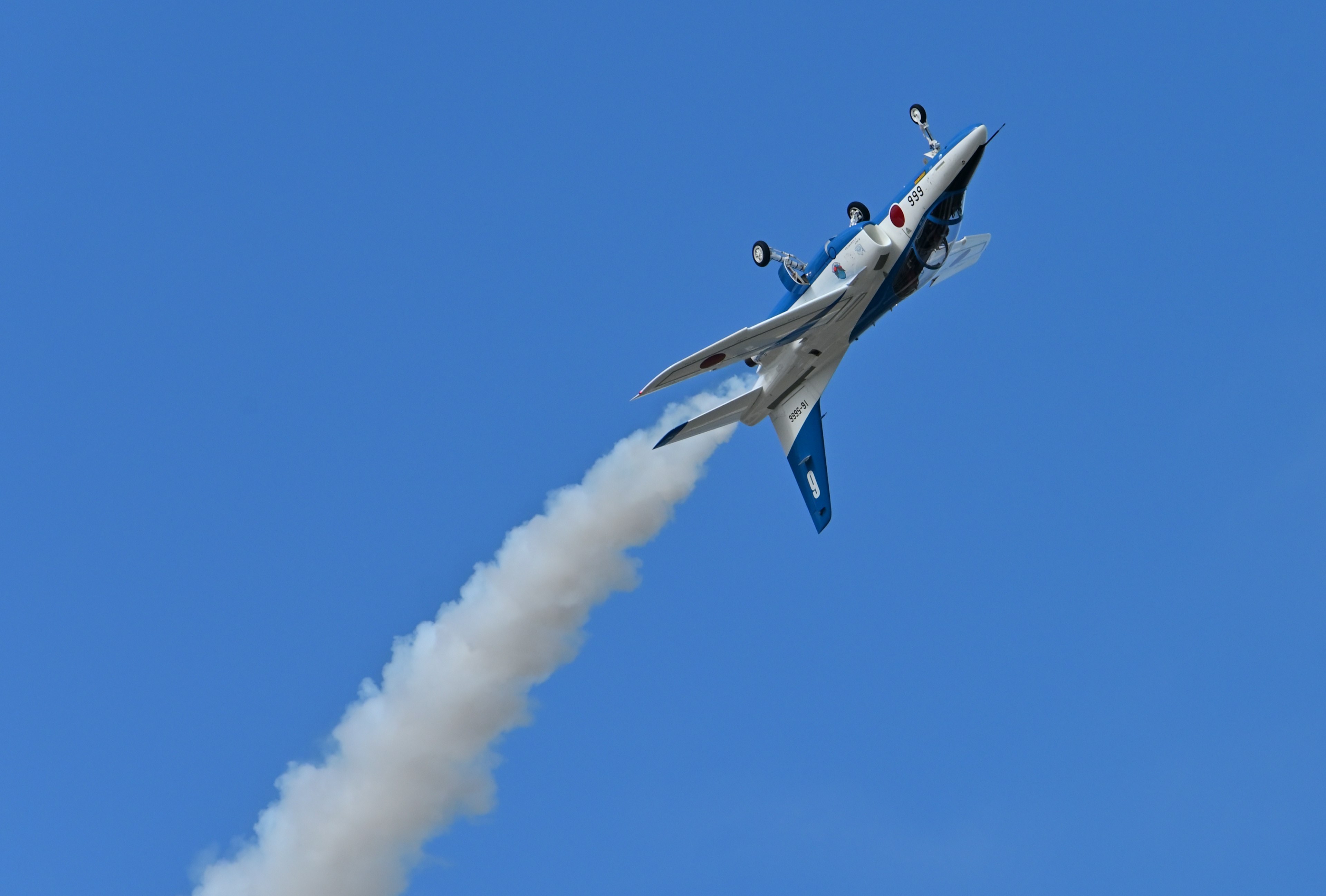 Bild eines Flugzeugs, das steil gegen einen blauen Himmel steigt