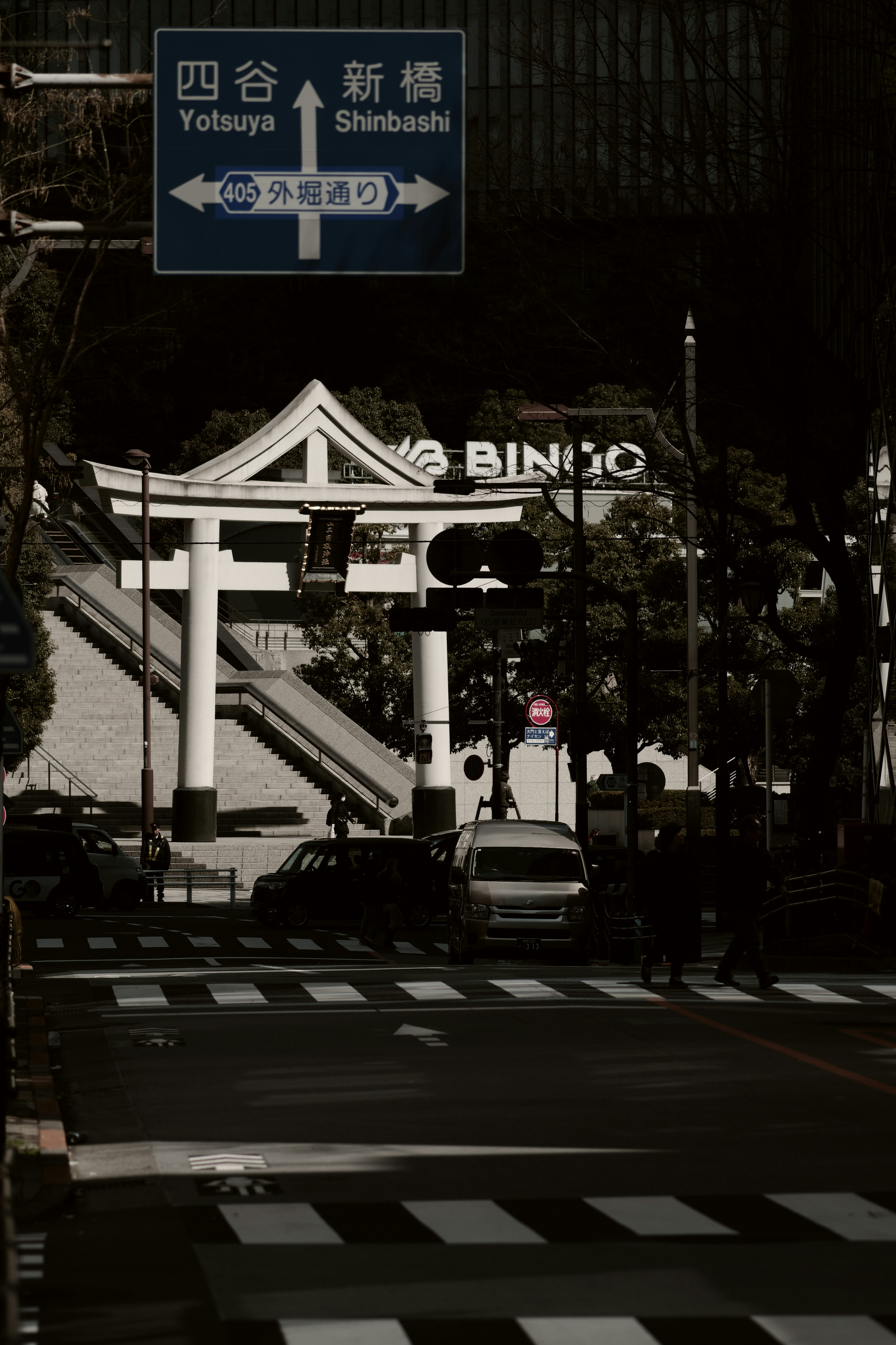 Vista de una puerta torii y un cartel en una intersección