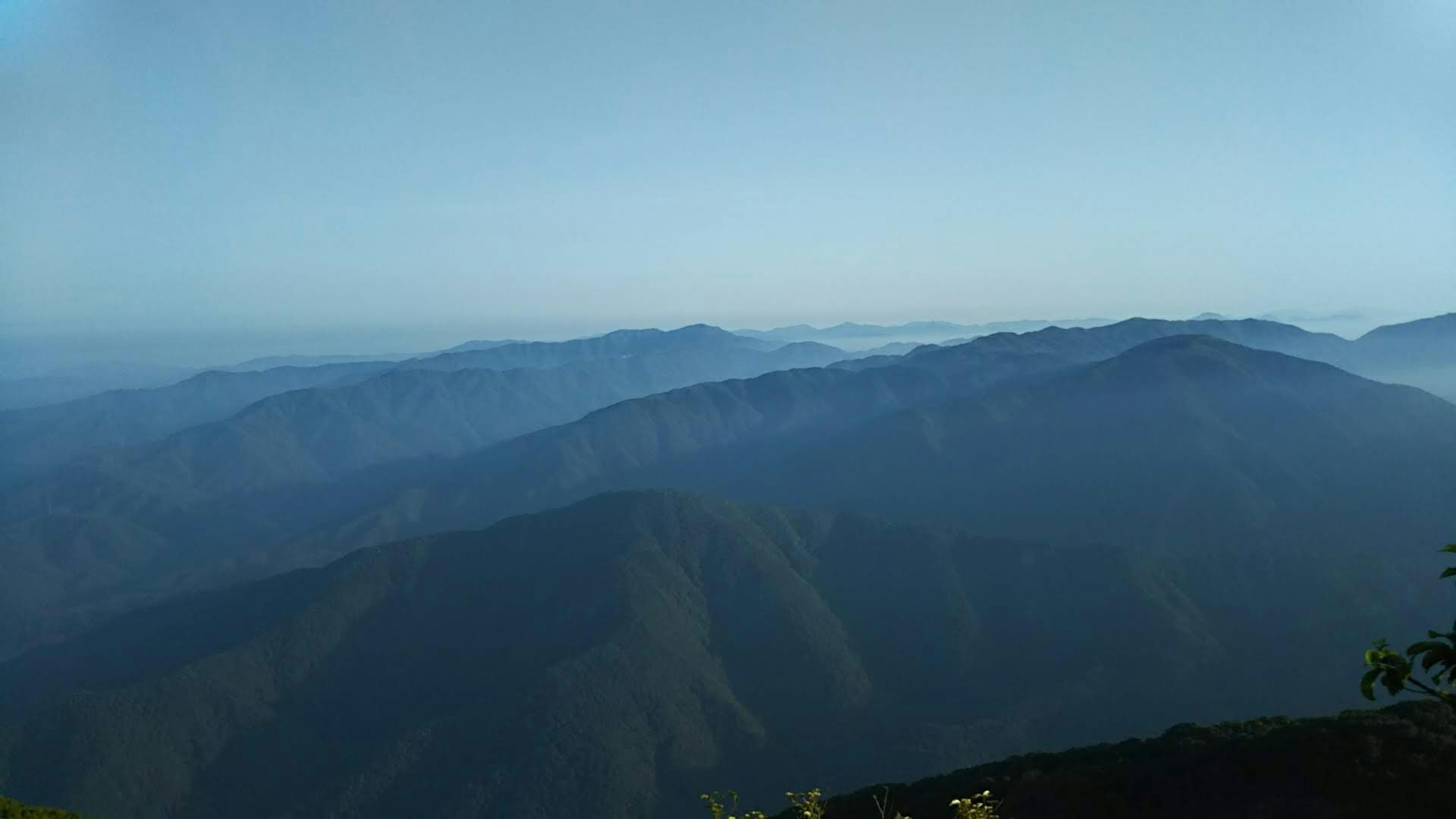 Silhouette blu delle montagne con un paesaggio nebbioso