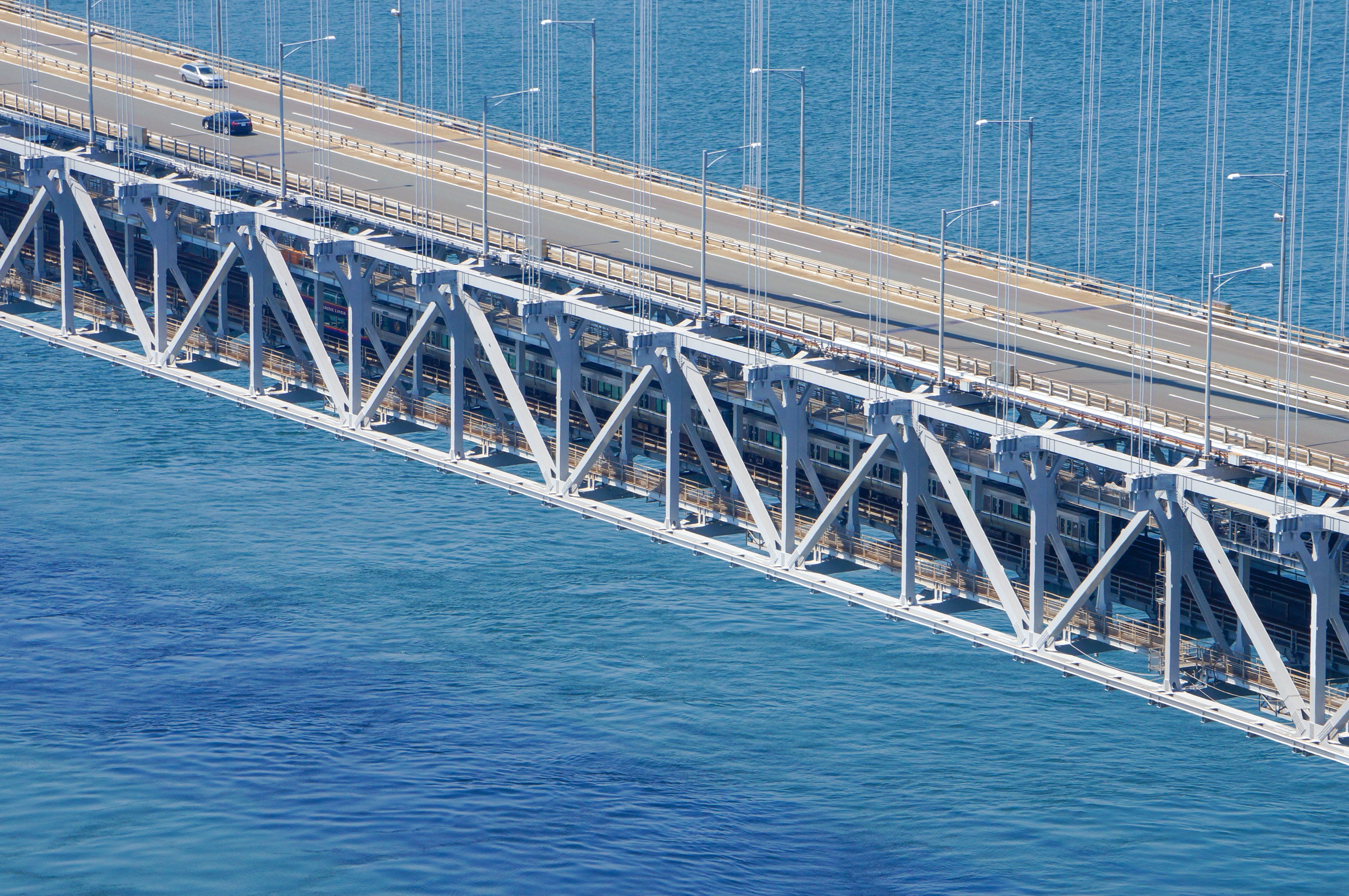 青い海に架かる現代的な橋の上を走る車