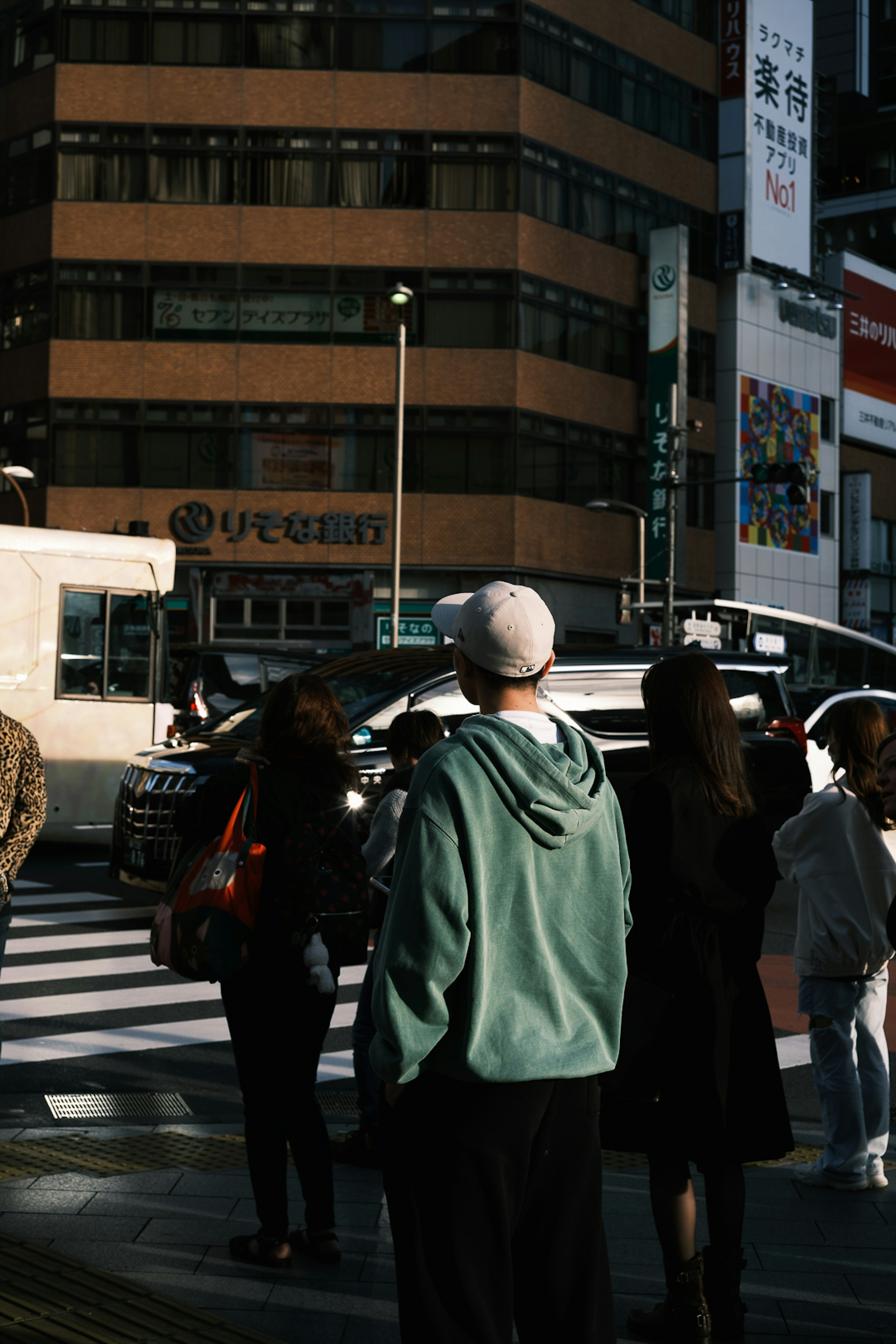 都市の交差点で立っている人々とビルの背景