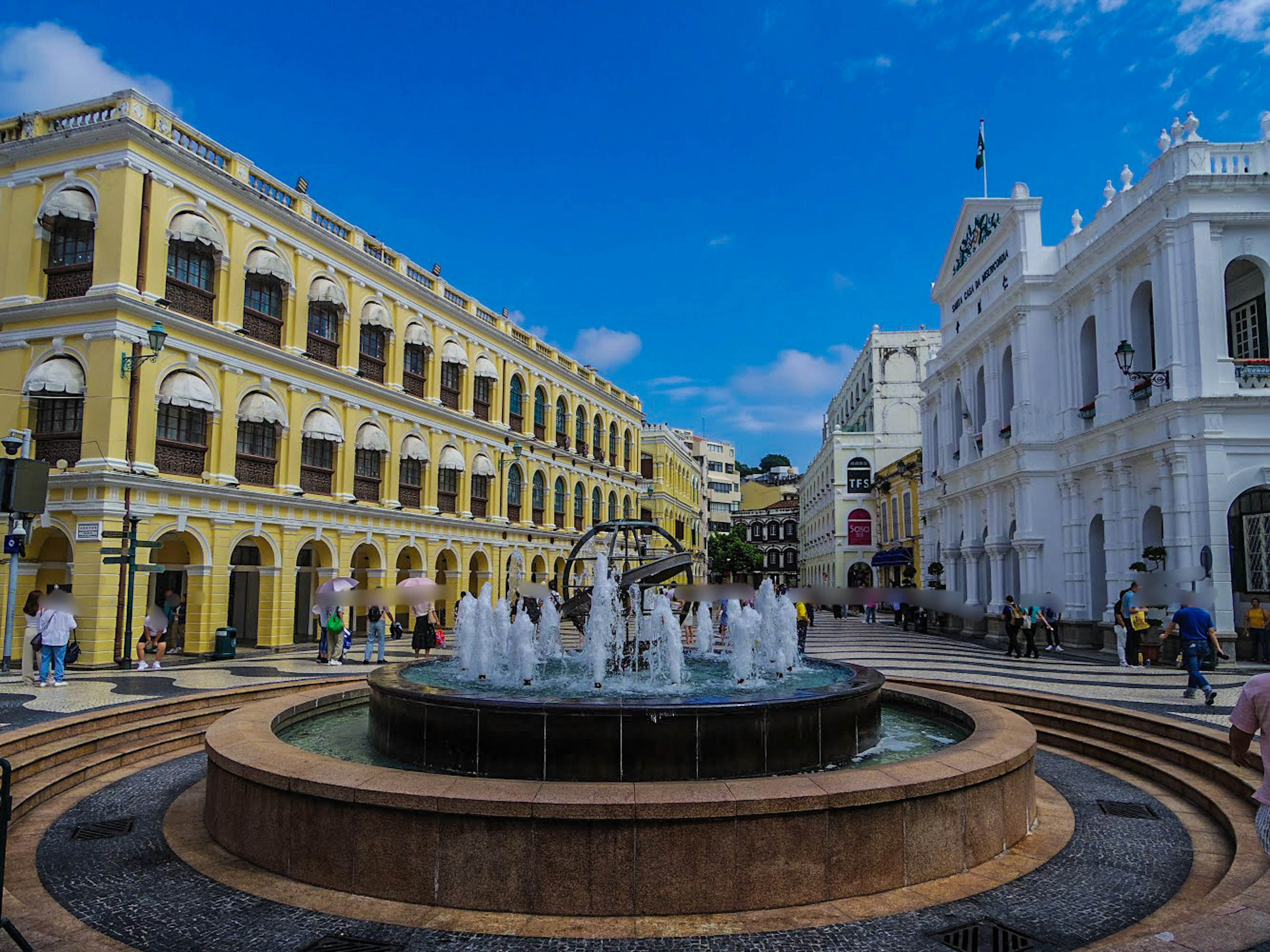 Fountain in a square surrounded by colorful buildings in Macau