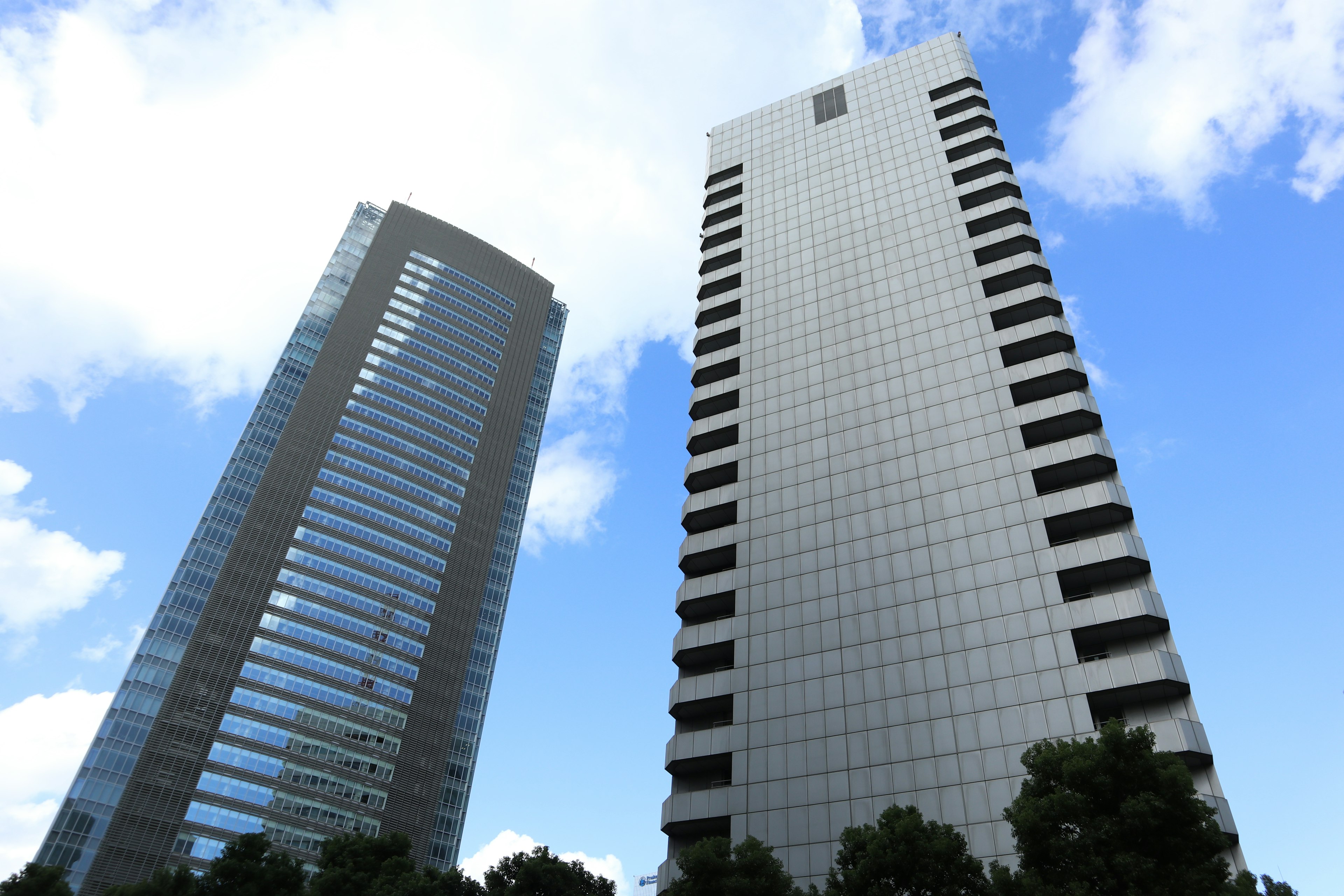 Two skyscrapers standing under a blue sky