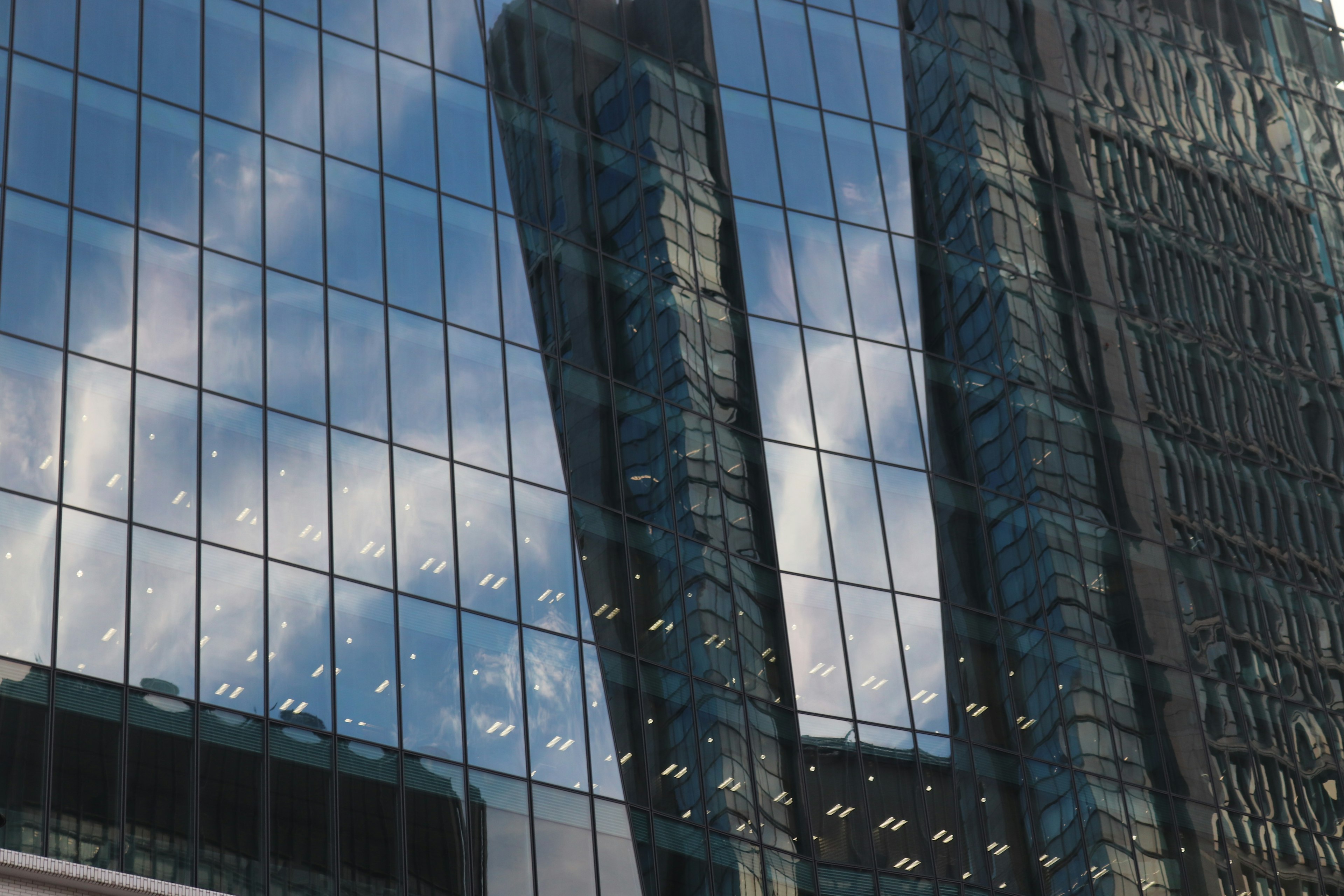 Refleksi awan di gedung pencakar langit kaca