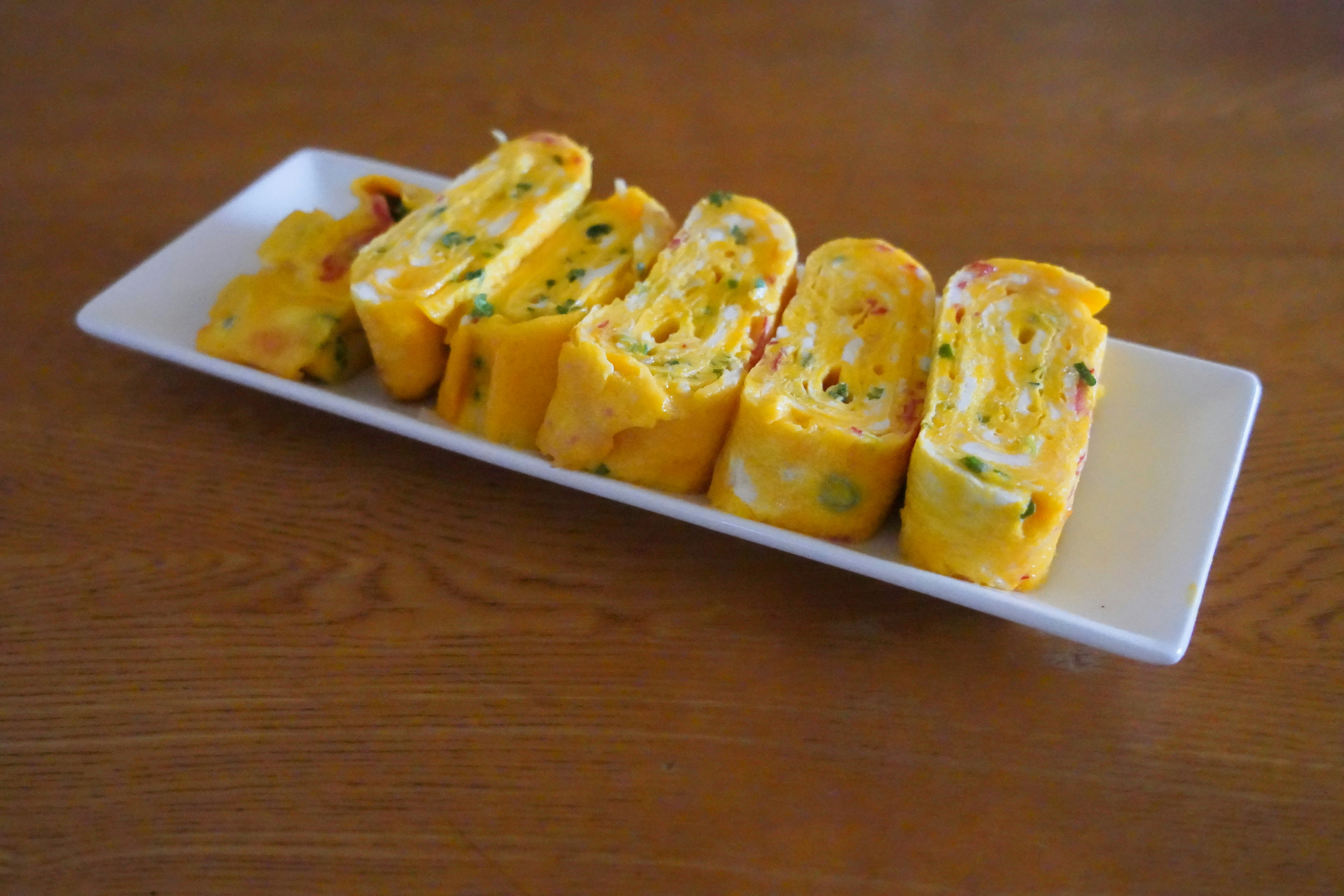 Delicious rolled omelette slices arranged on a white plate