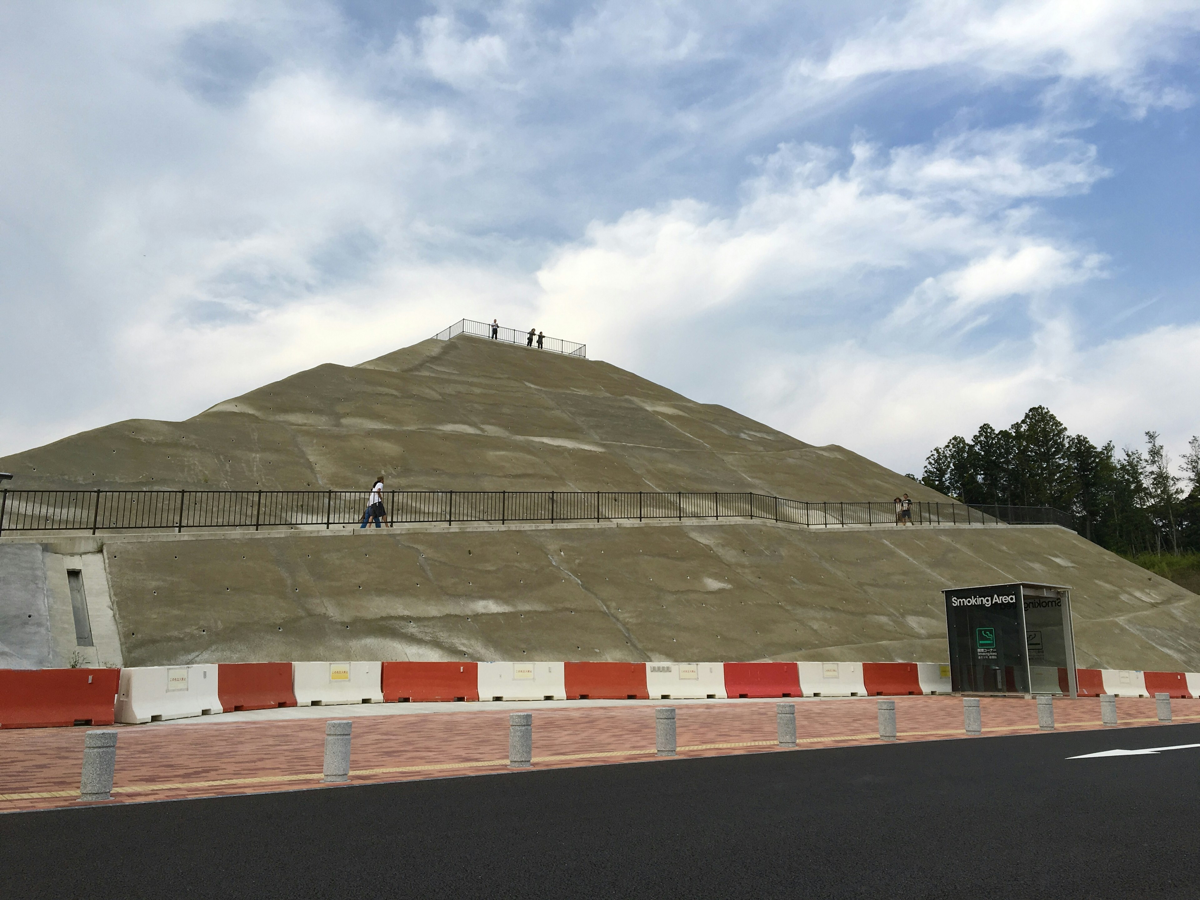 A green hill under a blue sky with people on top