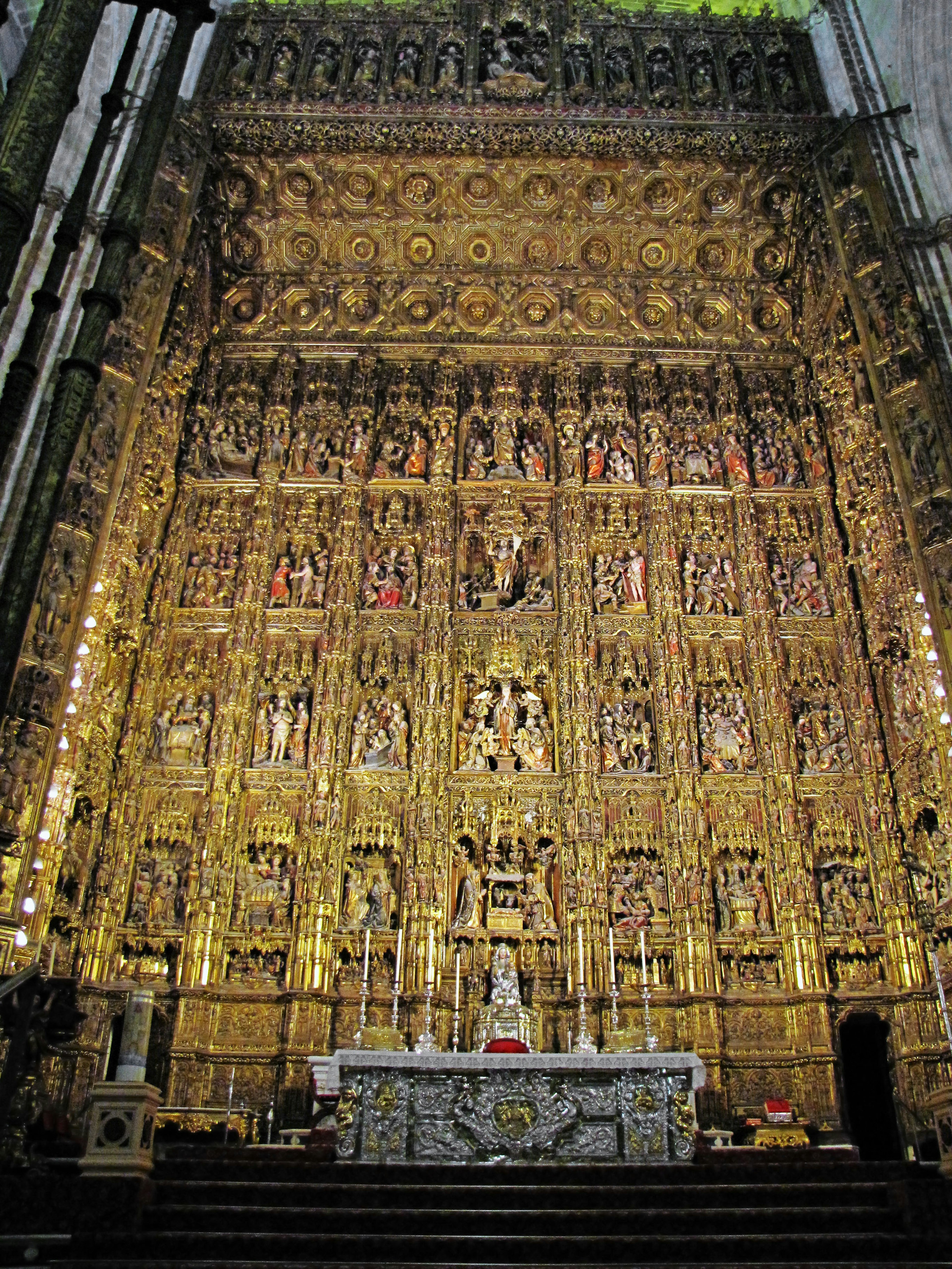 Interior gereja dengan altar emas megah dan ukiran dinding yang rumit