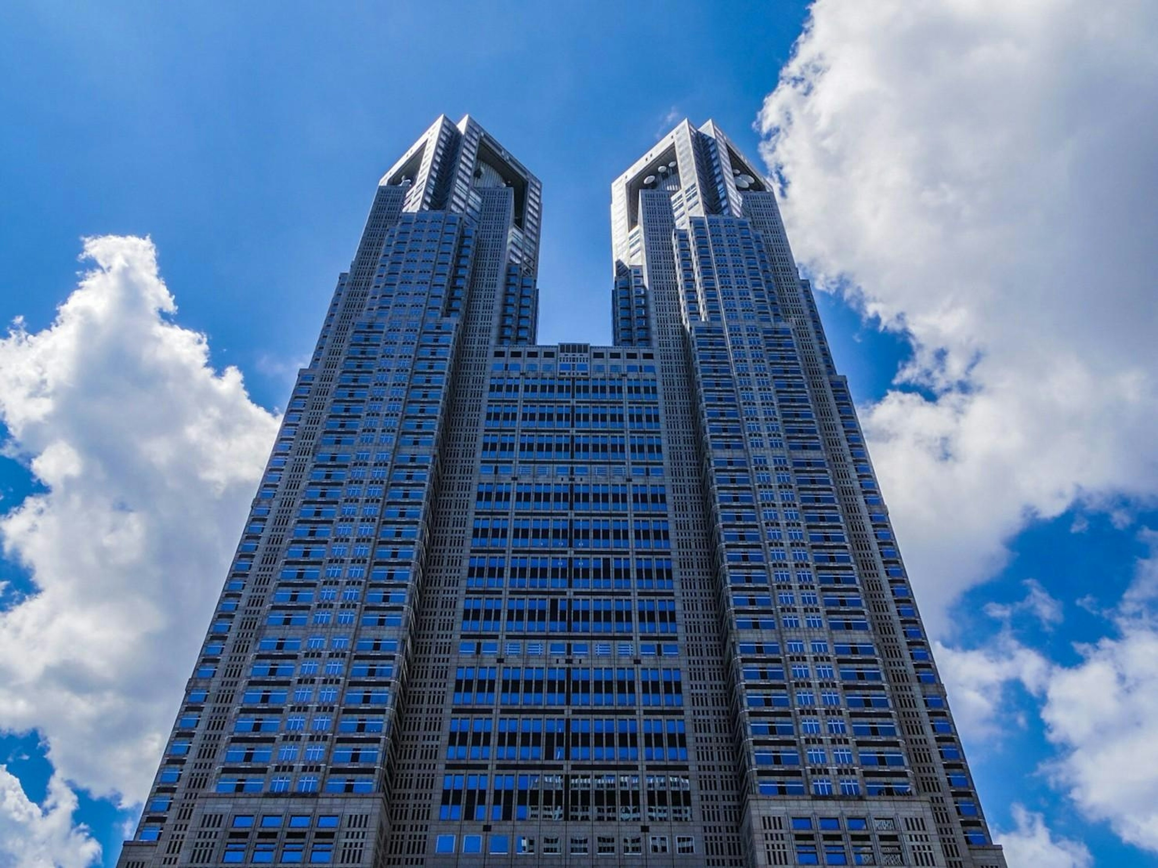 Foto gedung pencakar langit di Tokyo dengan langit biru dan awan putih