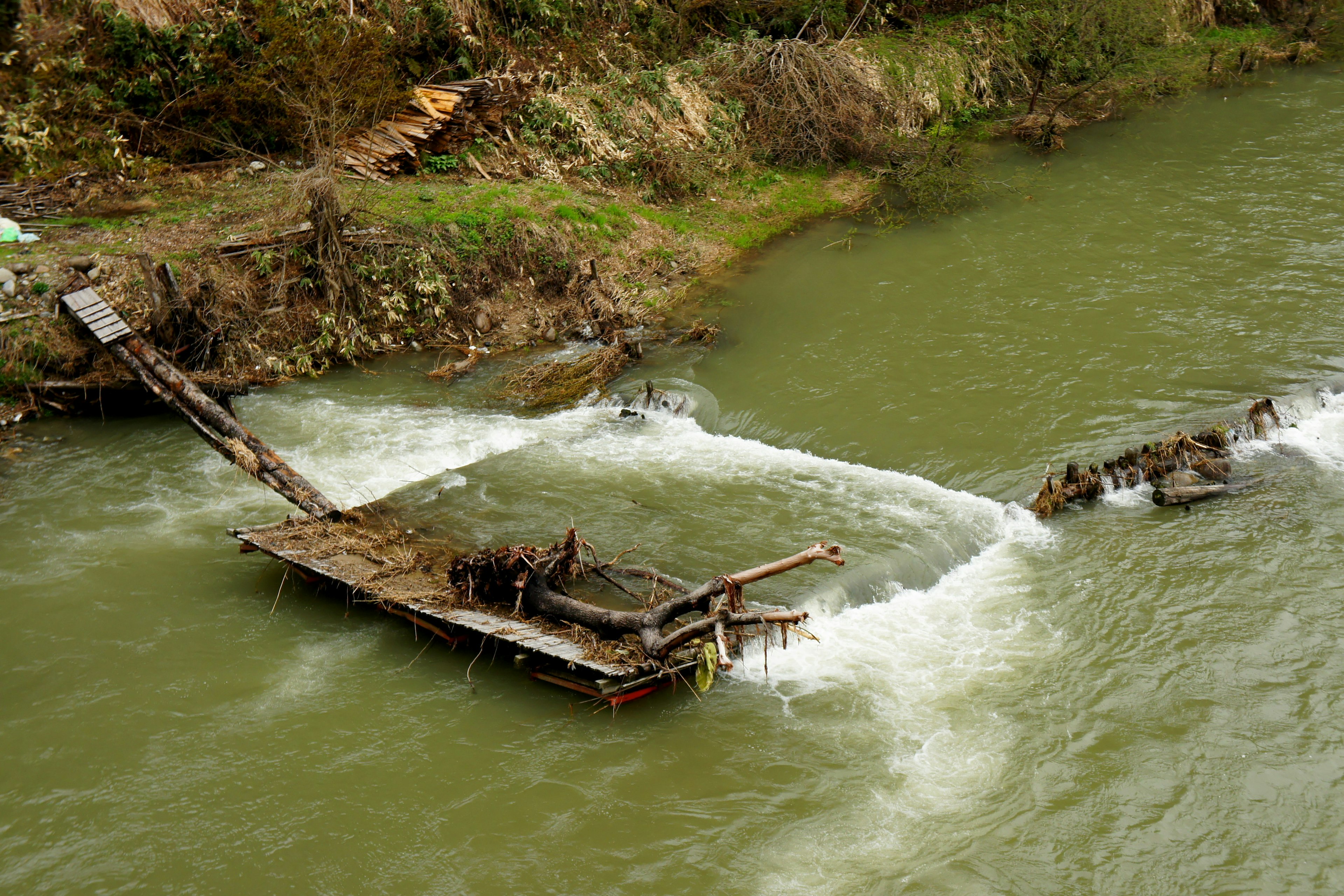 Rongsokan perahu kayu di air mengalir