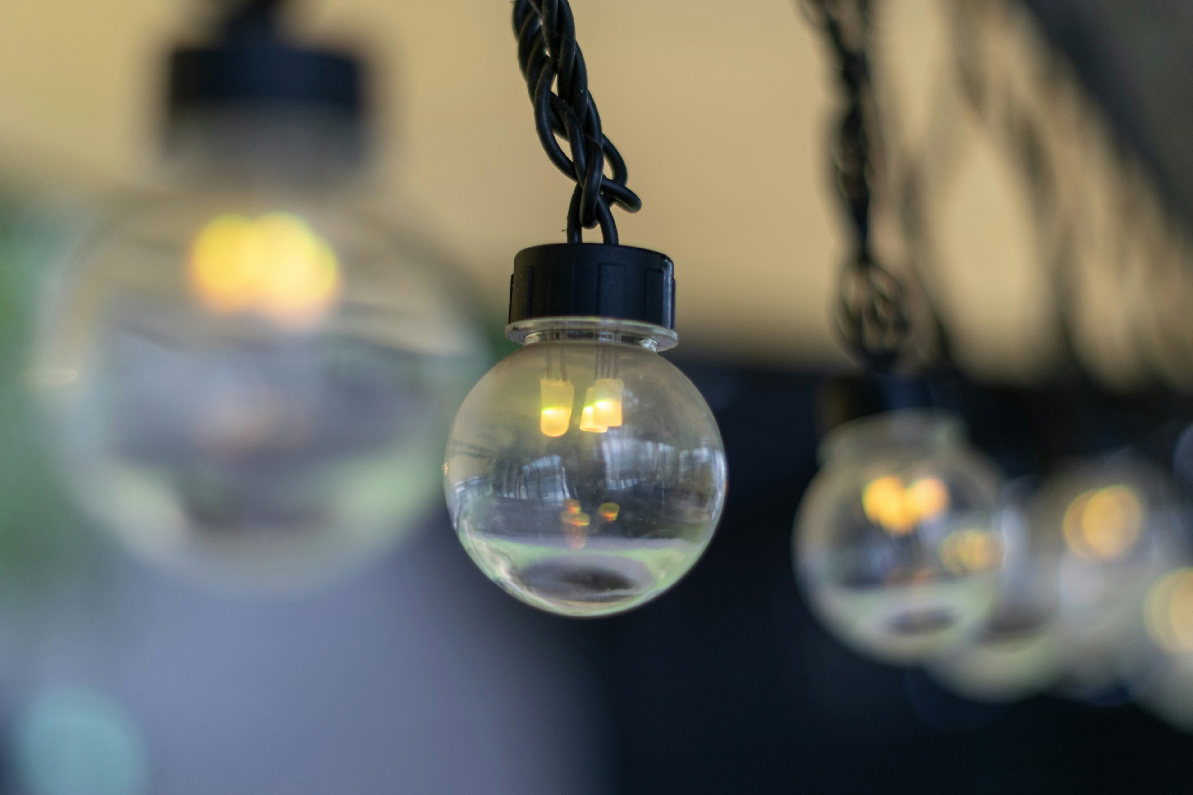 Clear spherical light bulbs hanging from a black chain