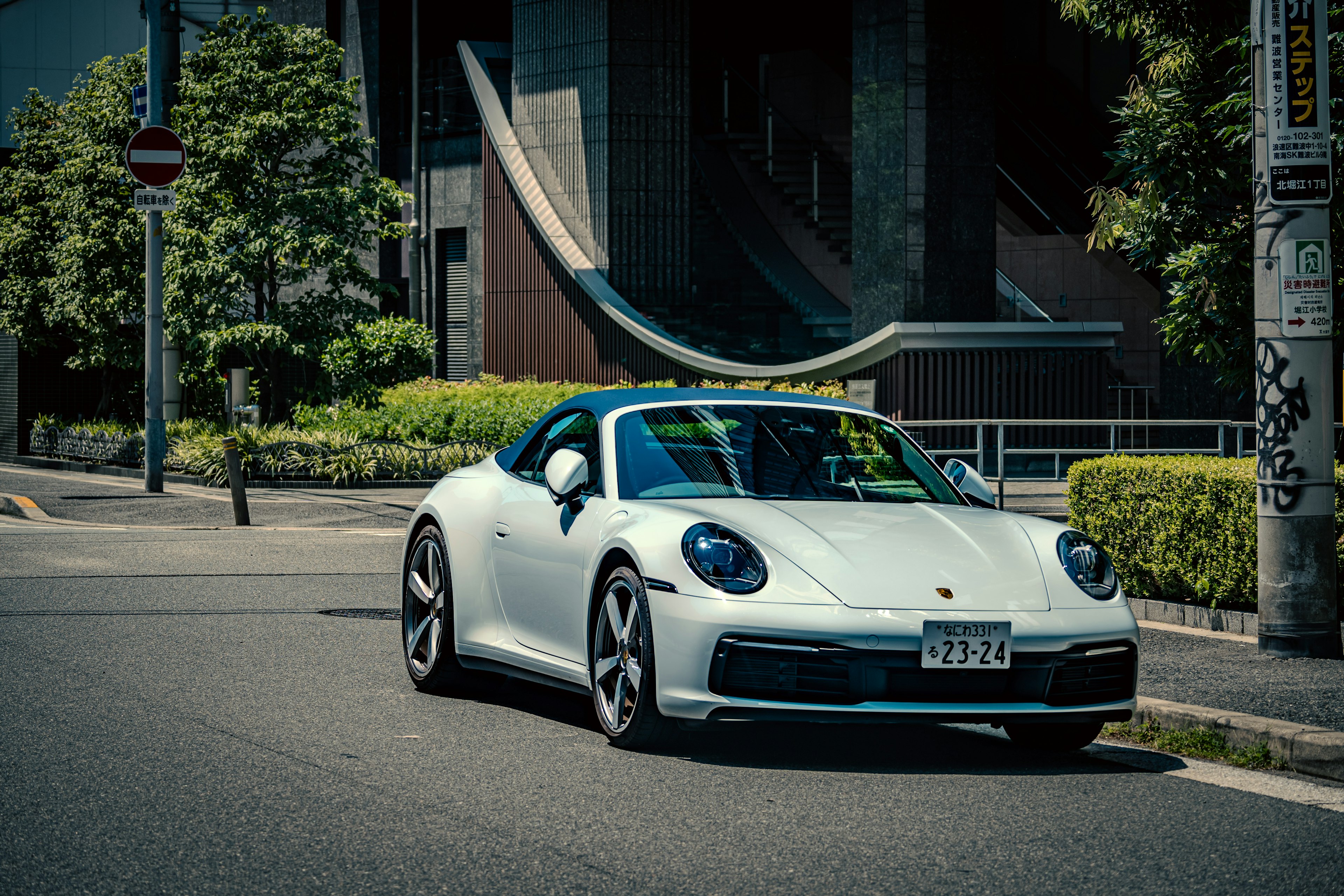 Porsche 911 blanca conduciendo por una calle de la ciudad