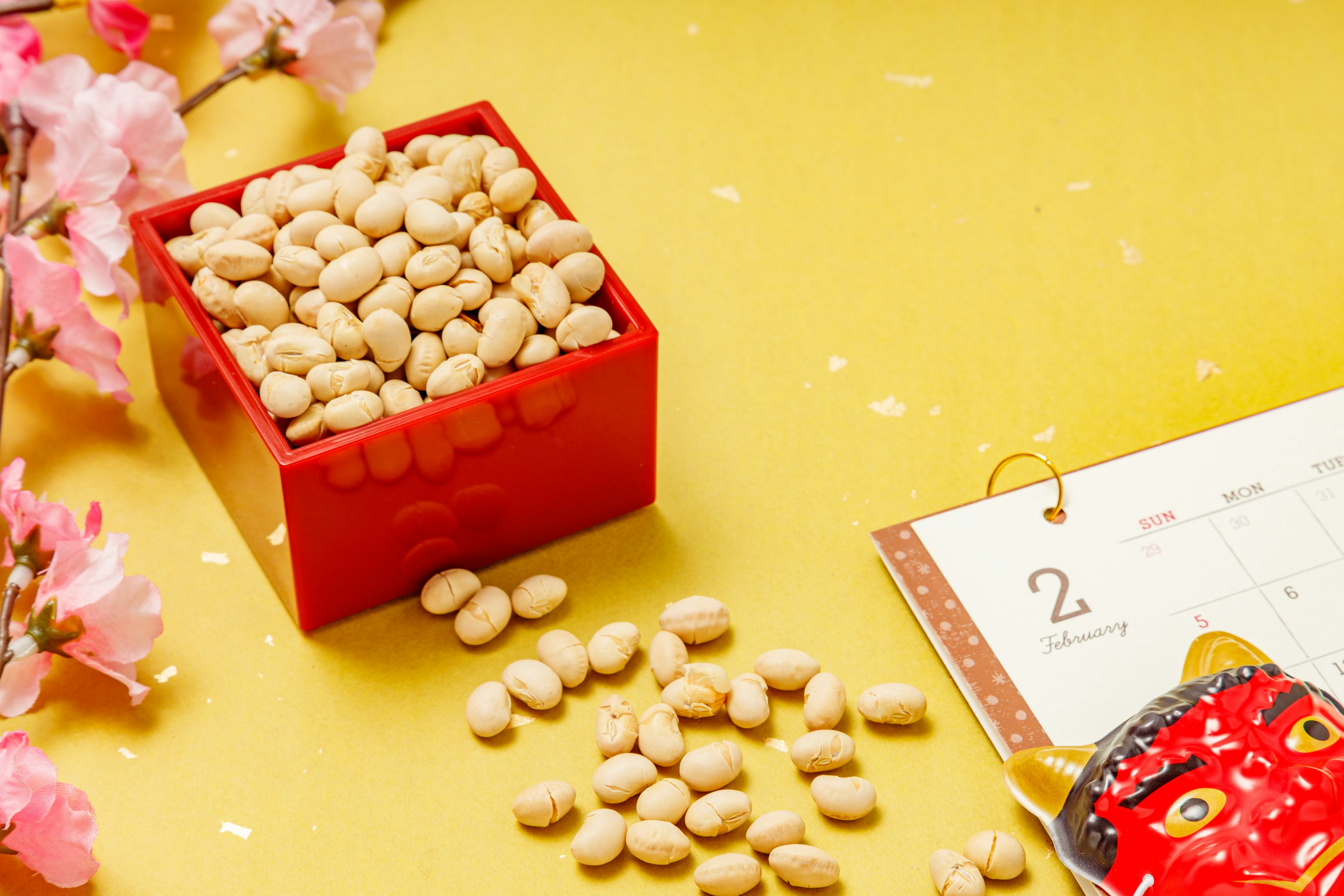 Red box filled with beans and a calendar with cherry blossoms