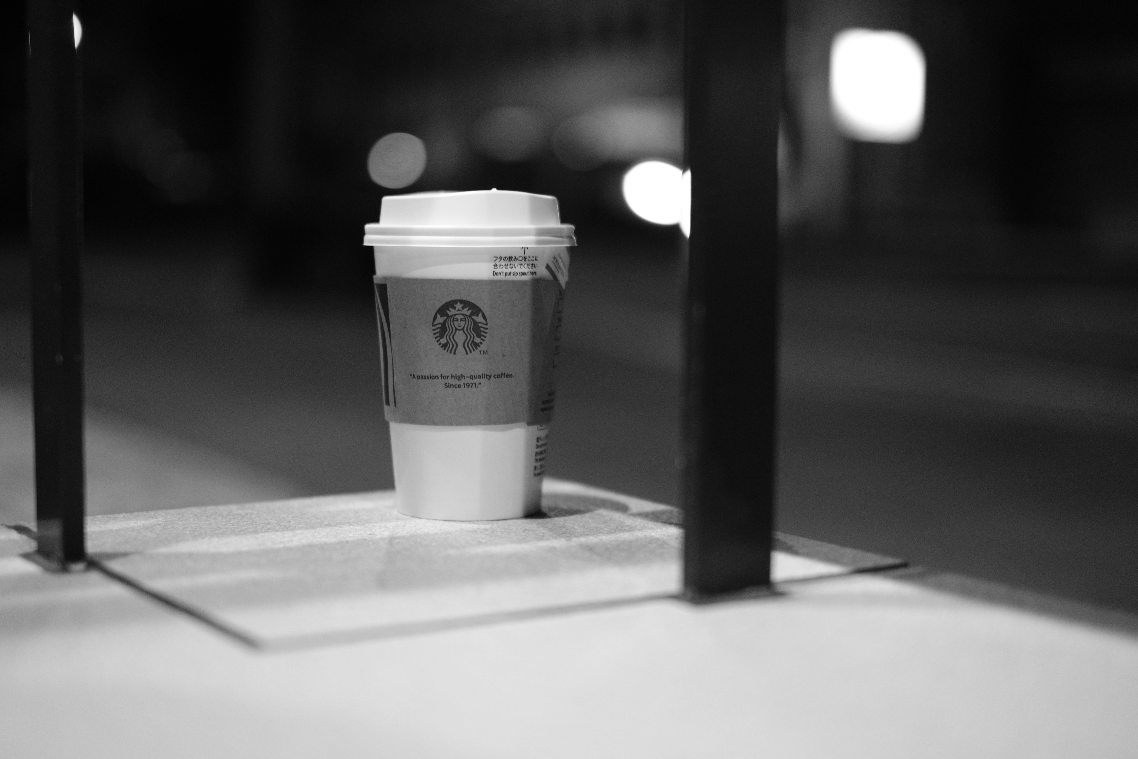 Taza de café de Starbucks colocada en una mesa en un ambiente nocturno