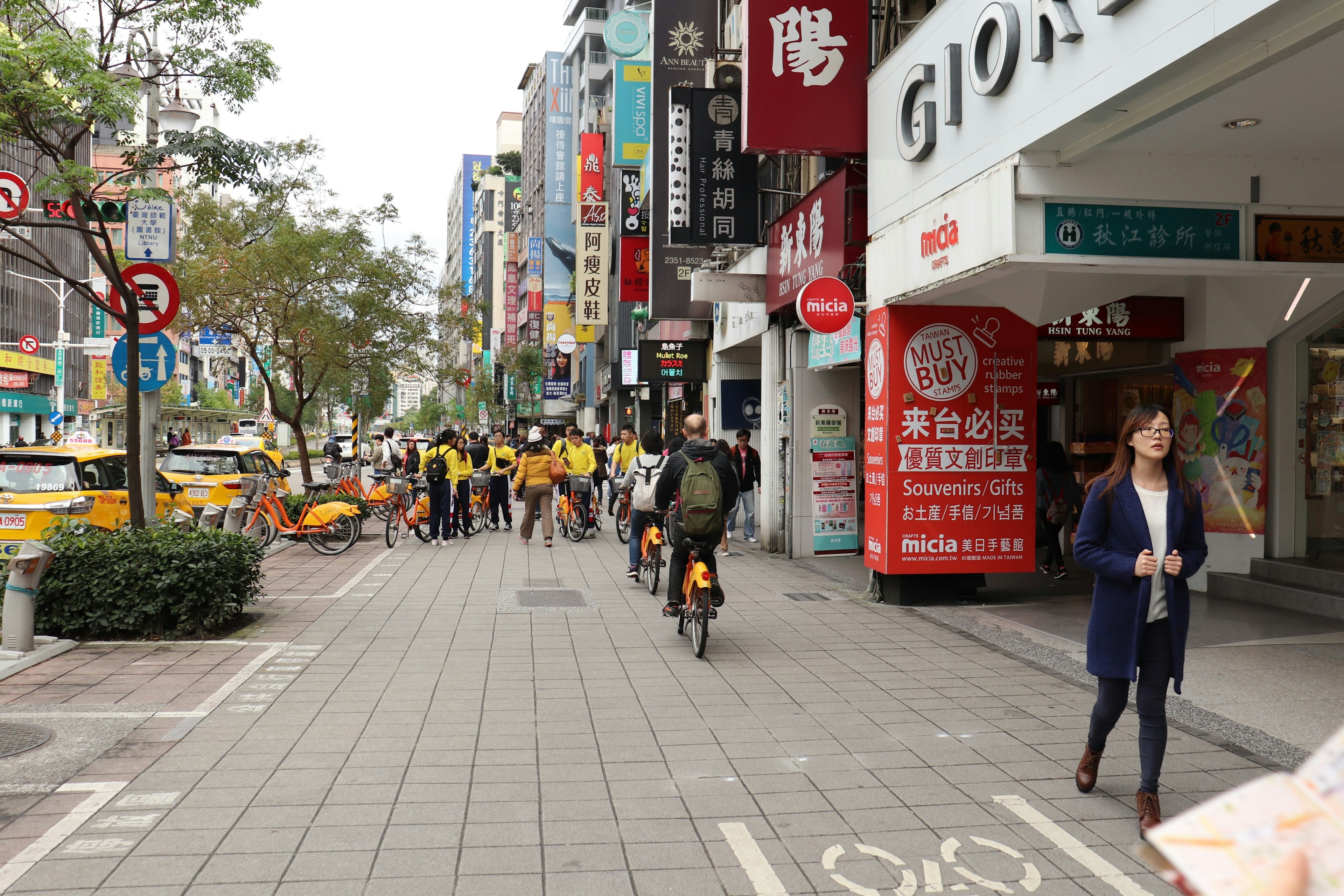 繁忙街道场景，有骑自行车的人和行人在生机勃勃的城市区域