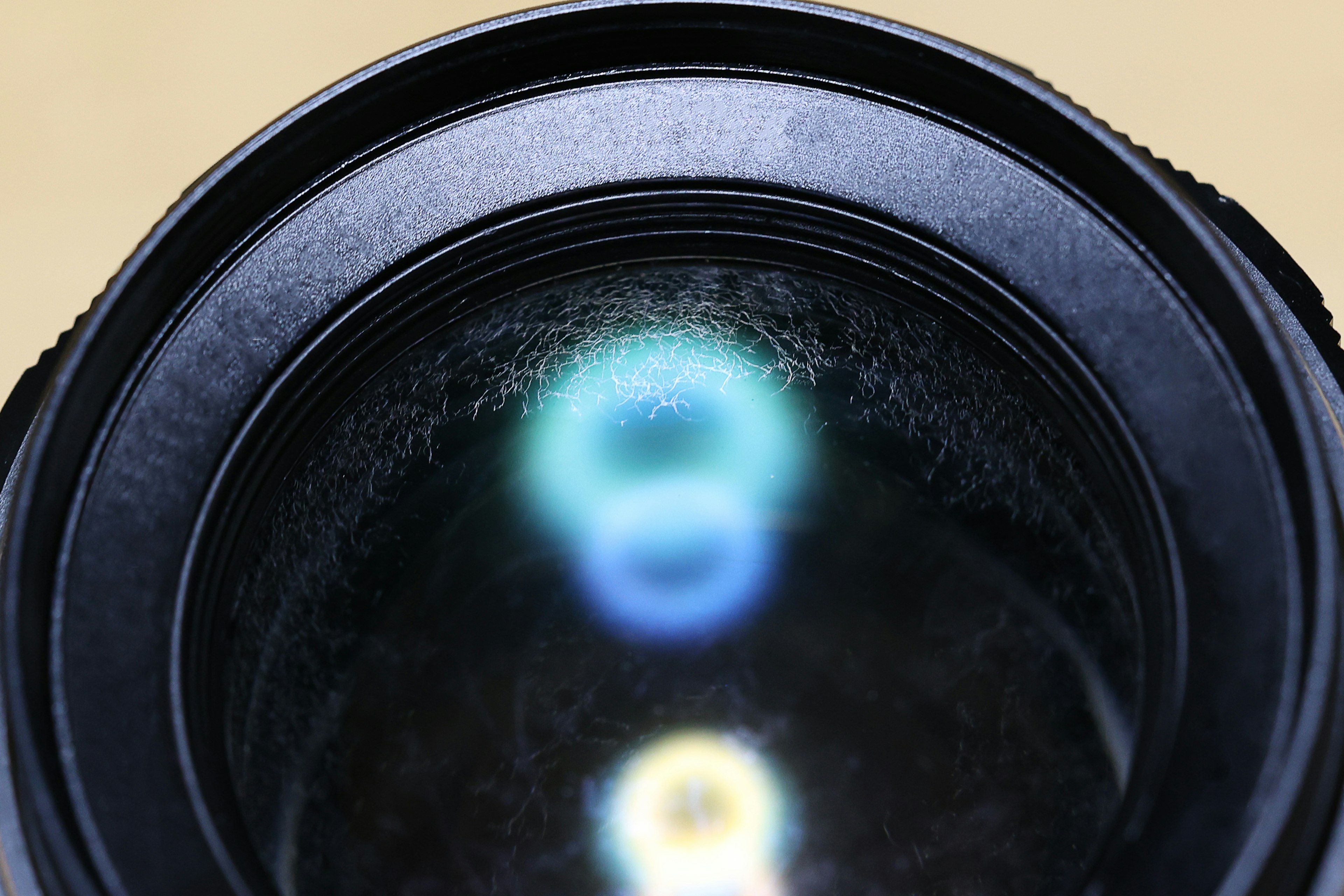 Close-up of a camera lens showing reflections of blue and white light