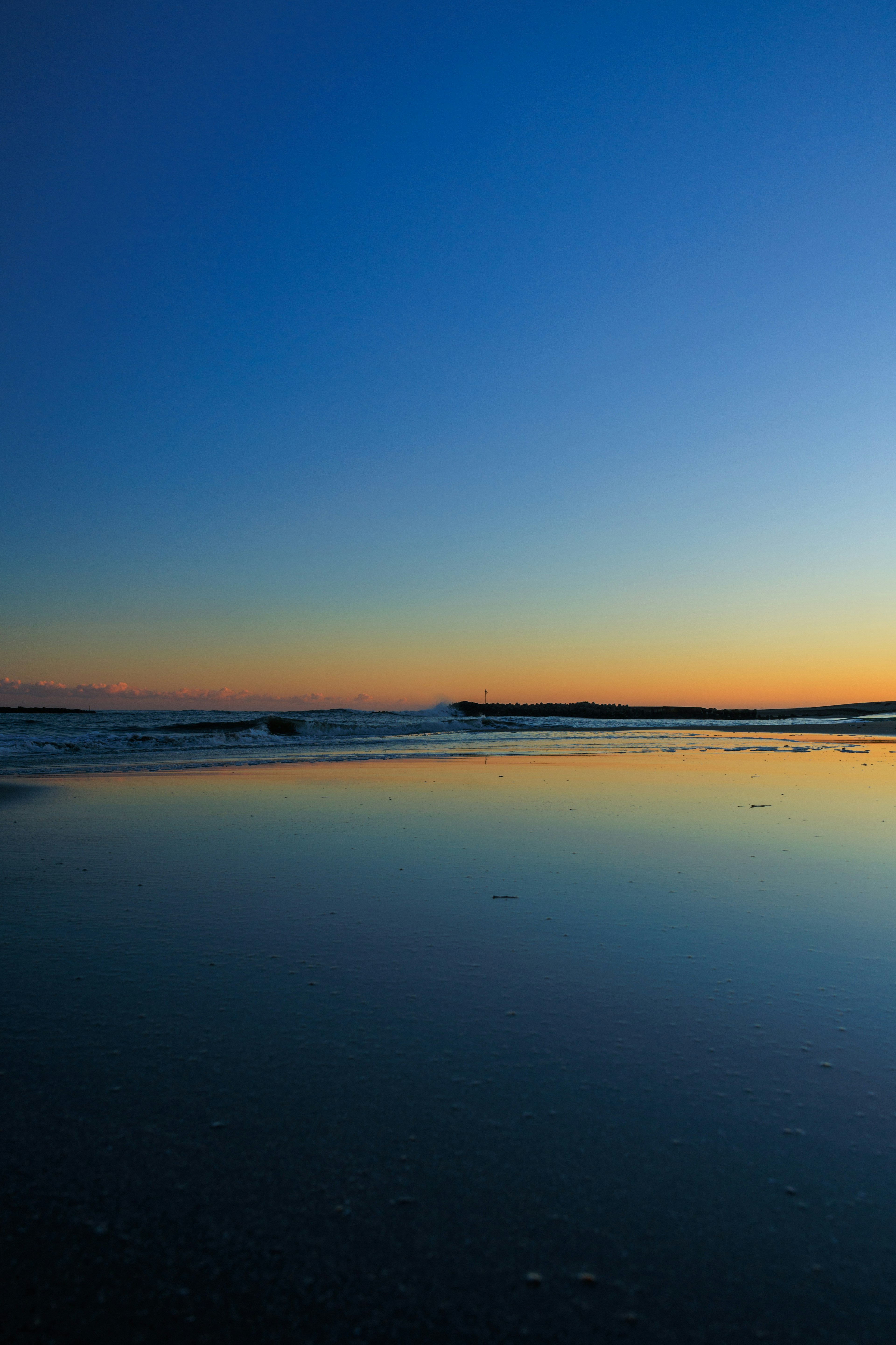 穏やかな海の景色と明るい青空が広がる夕暮れ時の風景