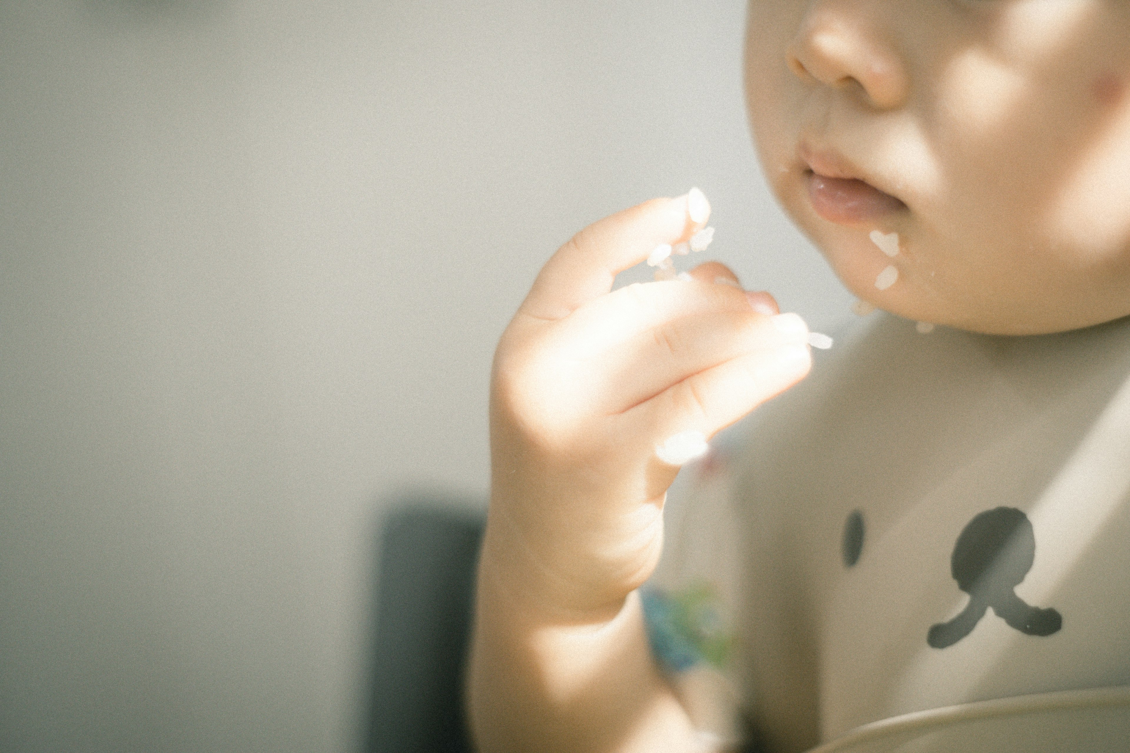 Primer plano de un niño sosteniendo comida en luz suave