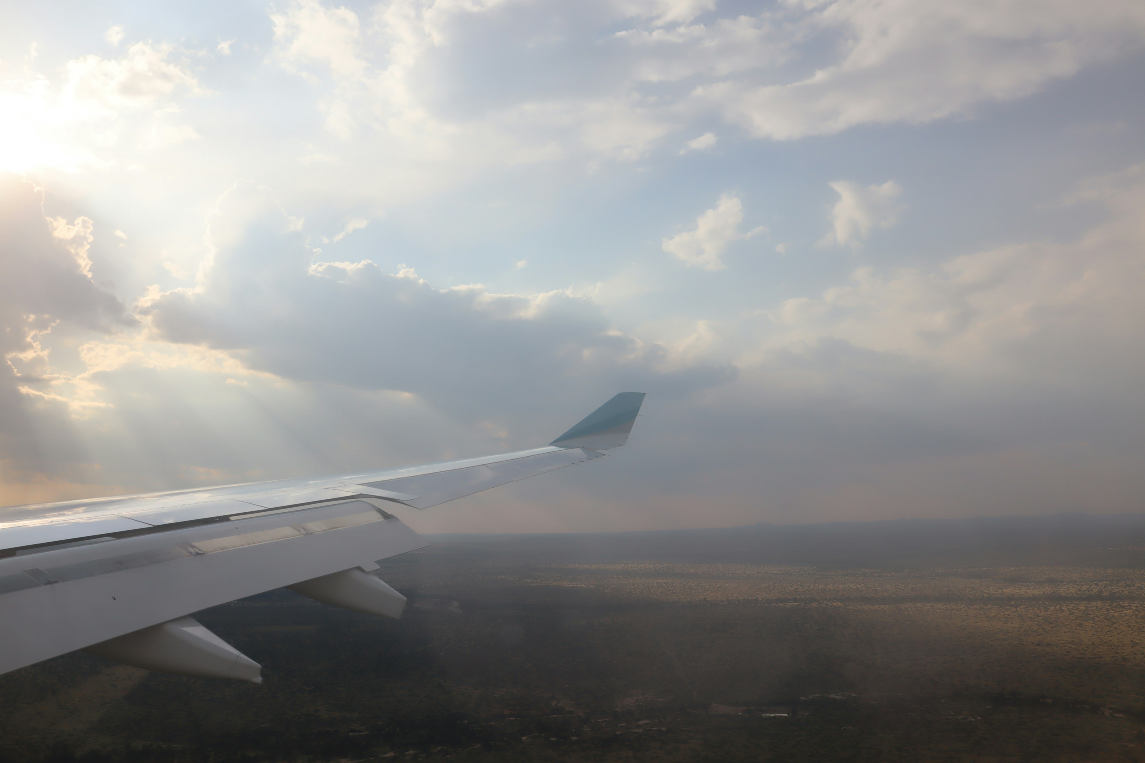 Flugzeugflügel mit weitem Blick auf Wolken