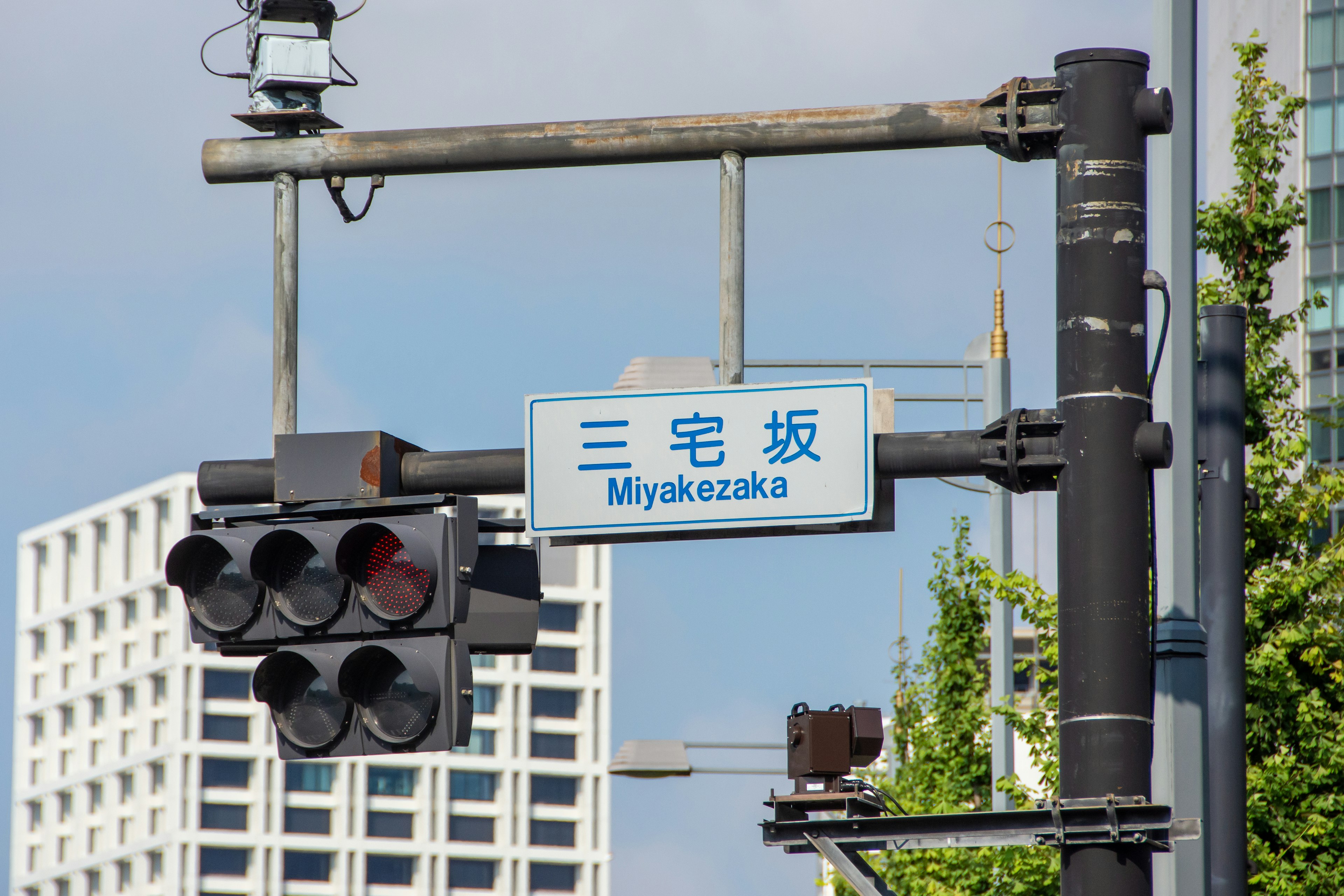 Semaforo e segnale per Miyakezaka in un'area urbana