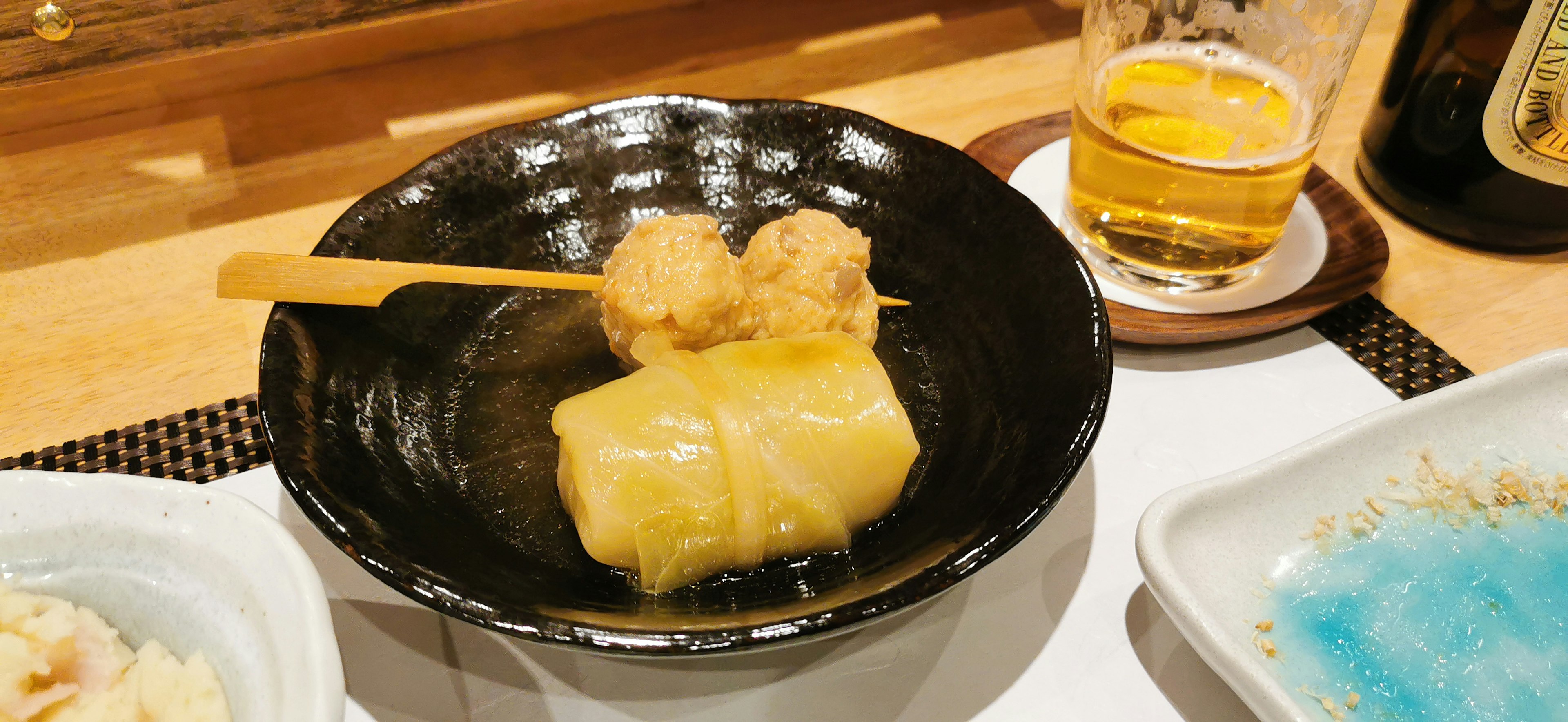 Warm dish served in a black bowl with skewered fried dumplings