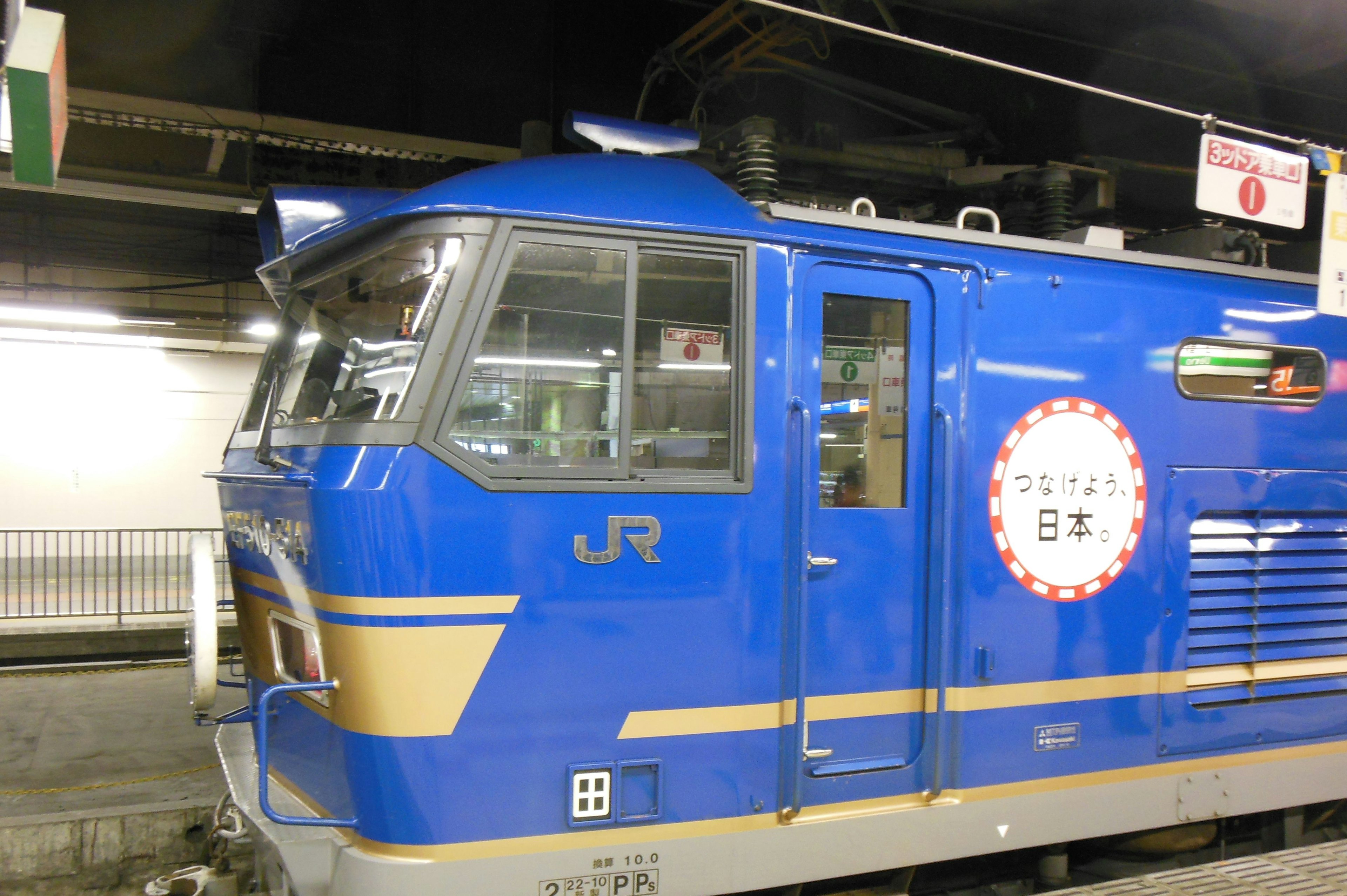 Close-up of a blue JR train locomotive at a station platform