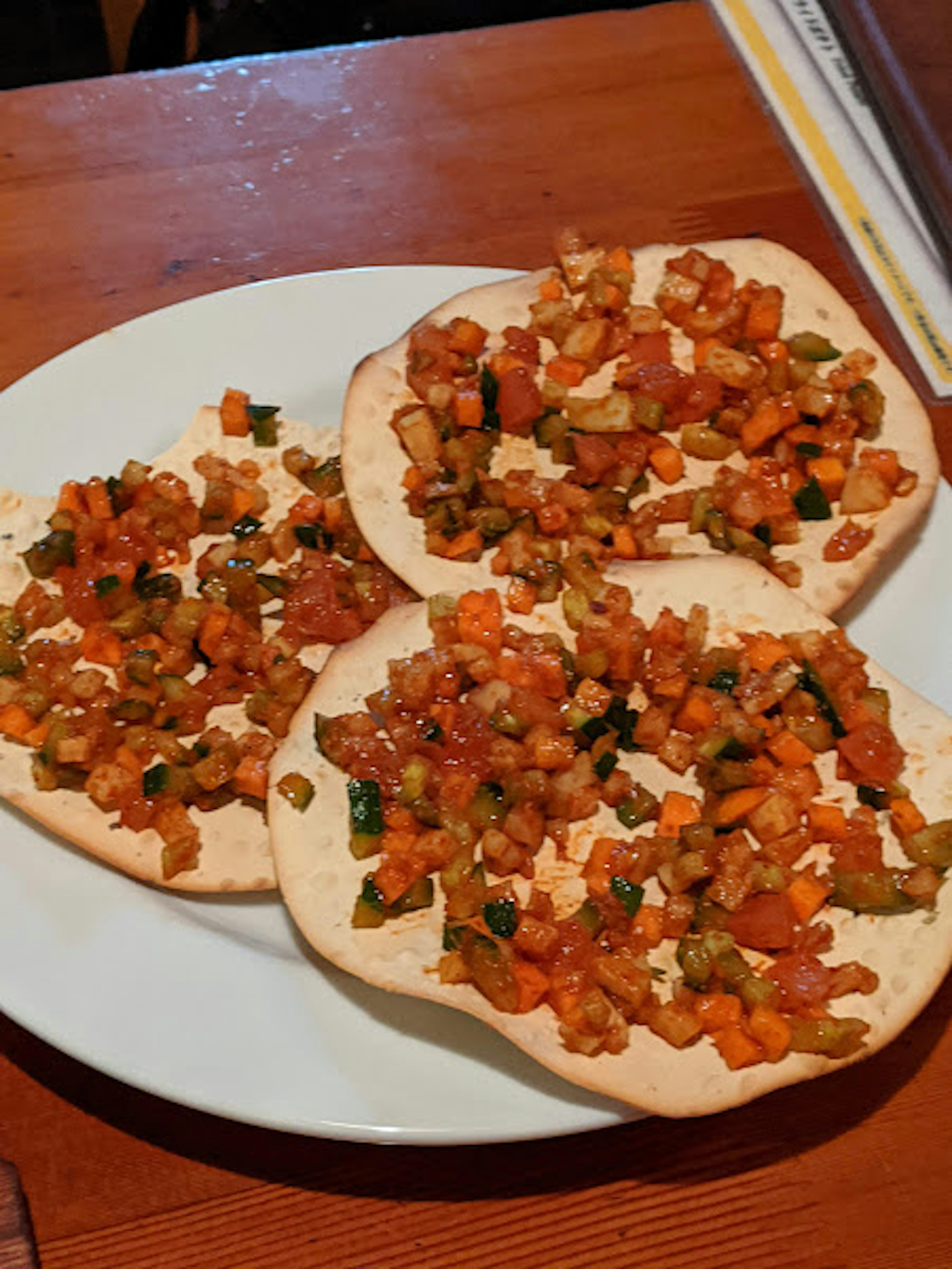 Tres tortillas cubiertas con una mezcla colorida de verduras y carne