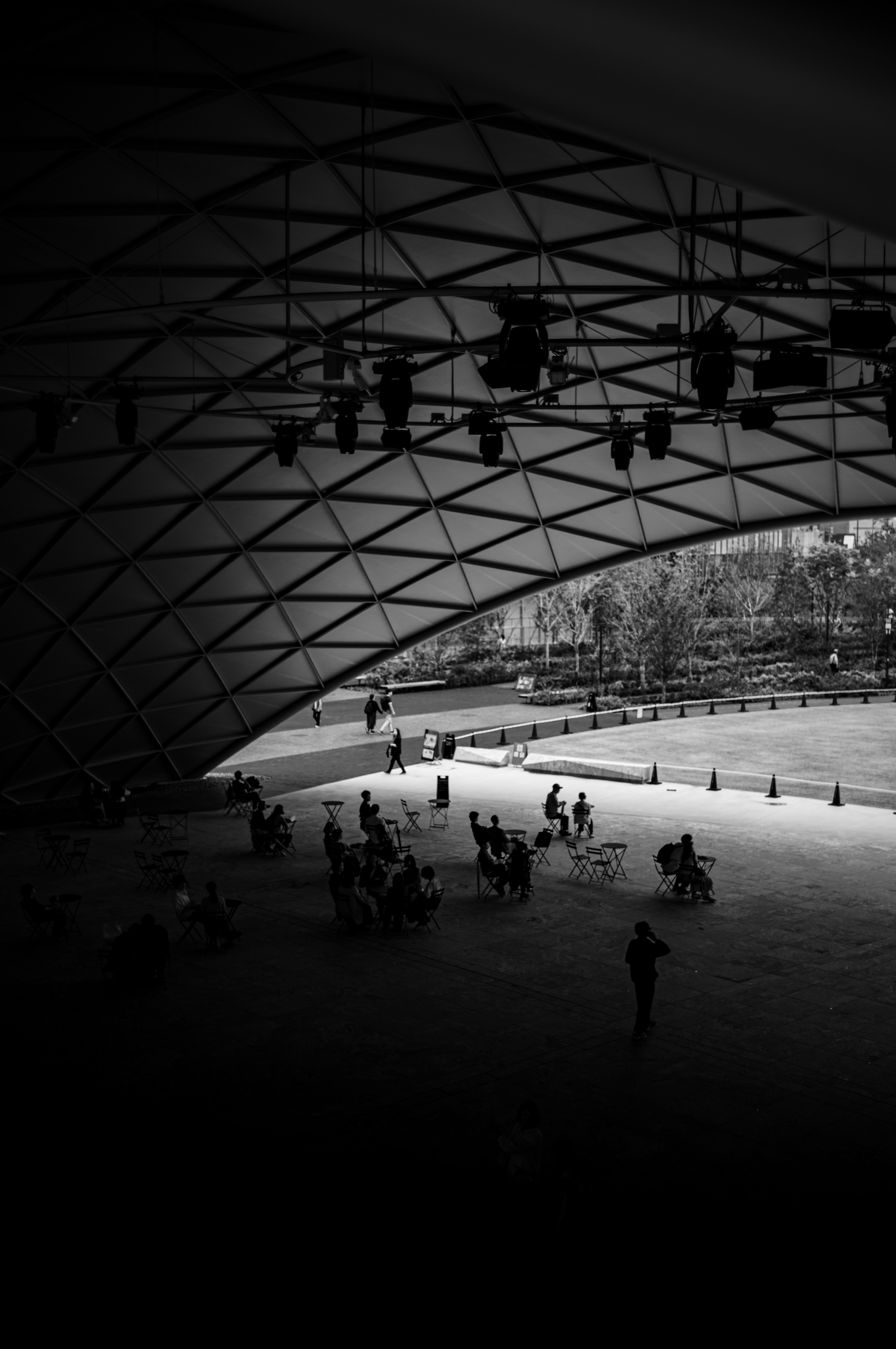 Silhouettes de personnes rassemblées sous un toit architectural moderne