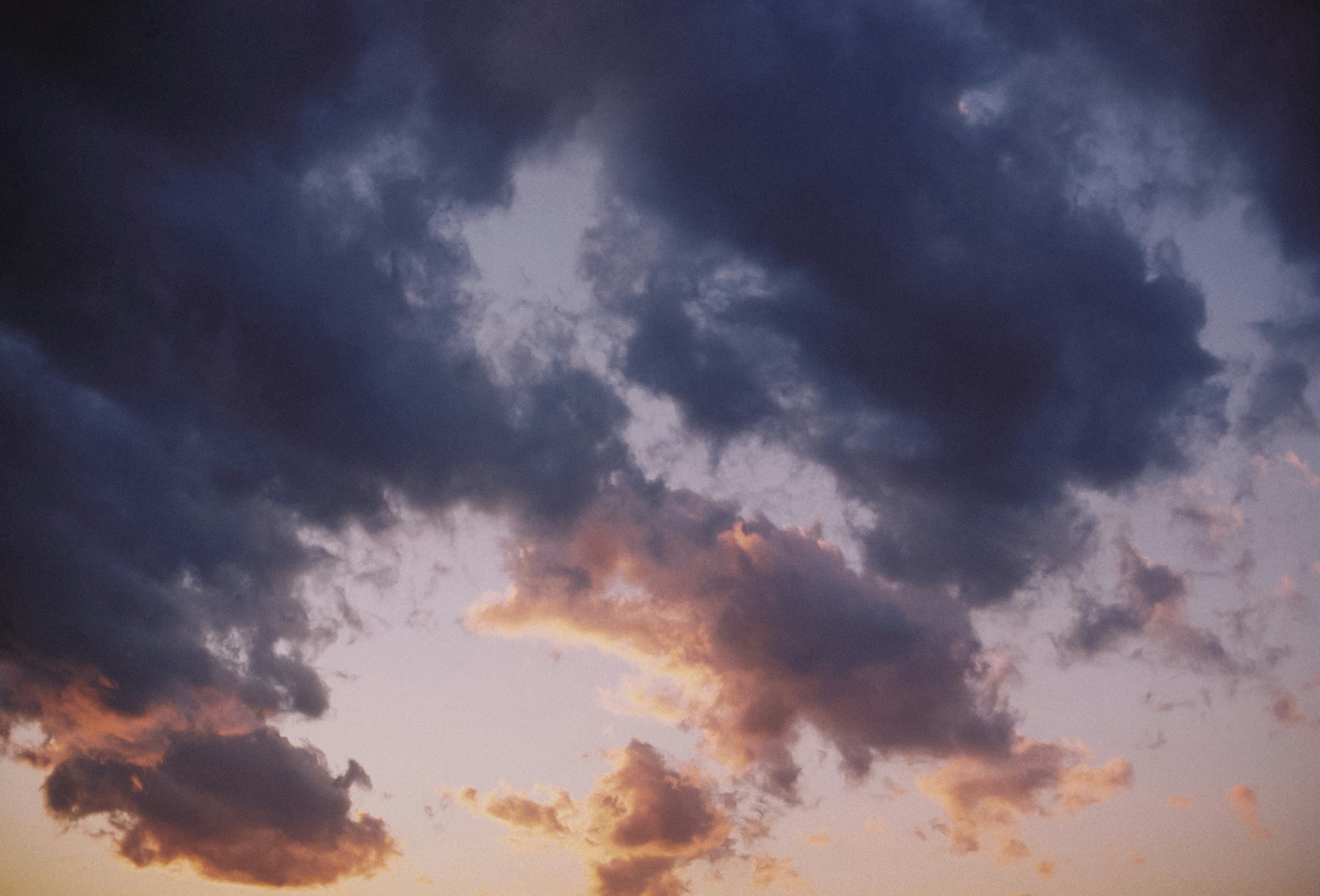 Dramatische Wolken bei Sonnenuntergang mit orangefarbenen und lila Akzenten