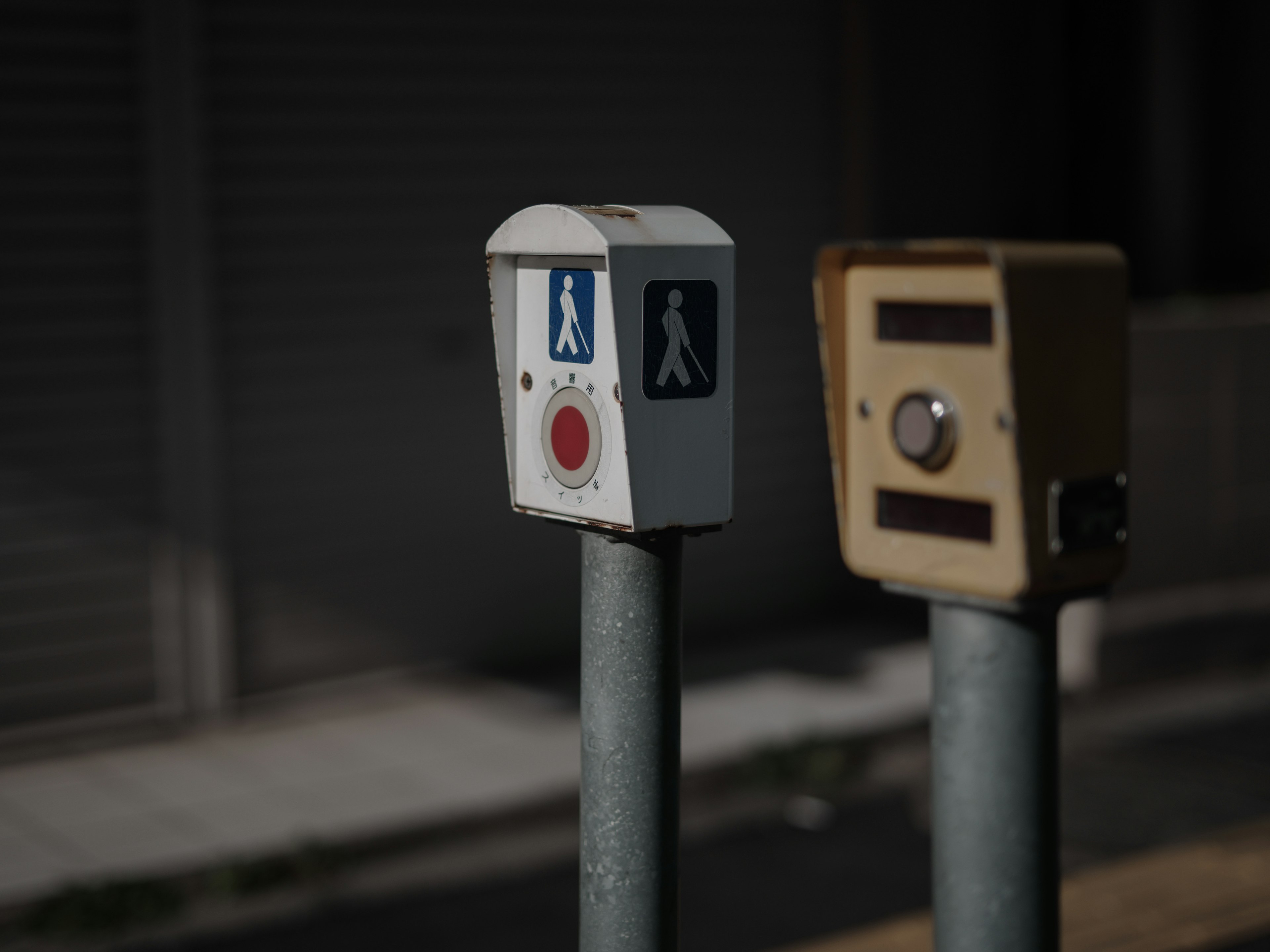 Two pedestrian signal boxes with buttons and icons