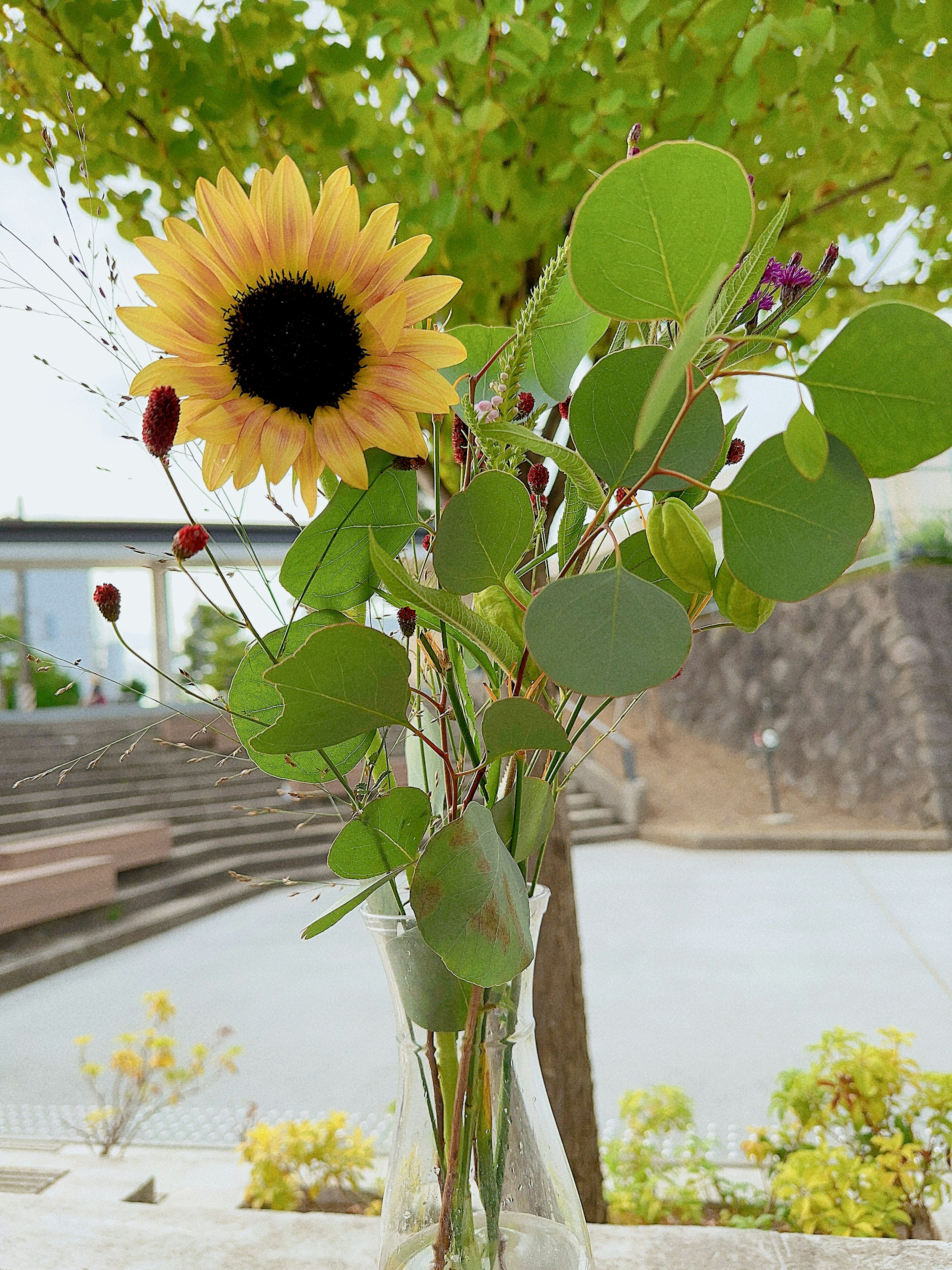 Eine Vase mit einem Arrangement aus Sonnenblumen und grünen Blättern