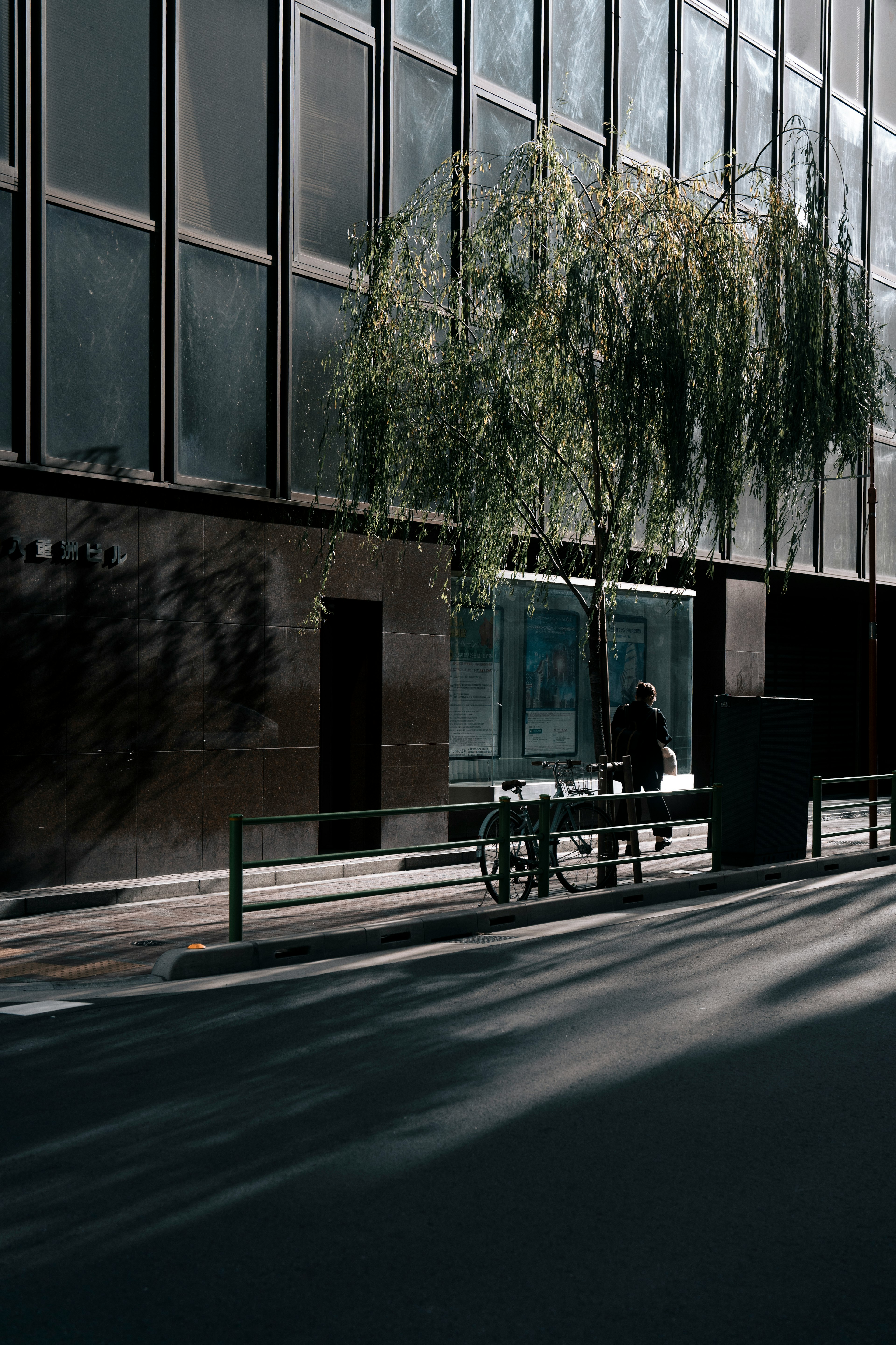 Städtische Szene mit einer Bank und dem Schatten eines Baumes