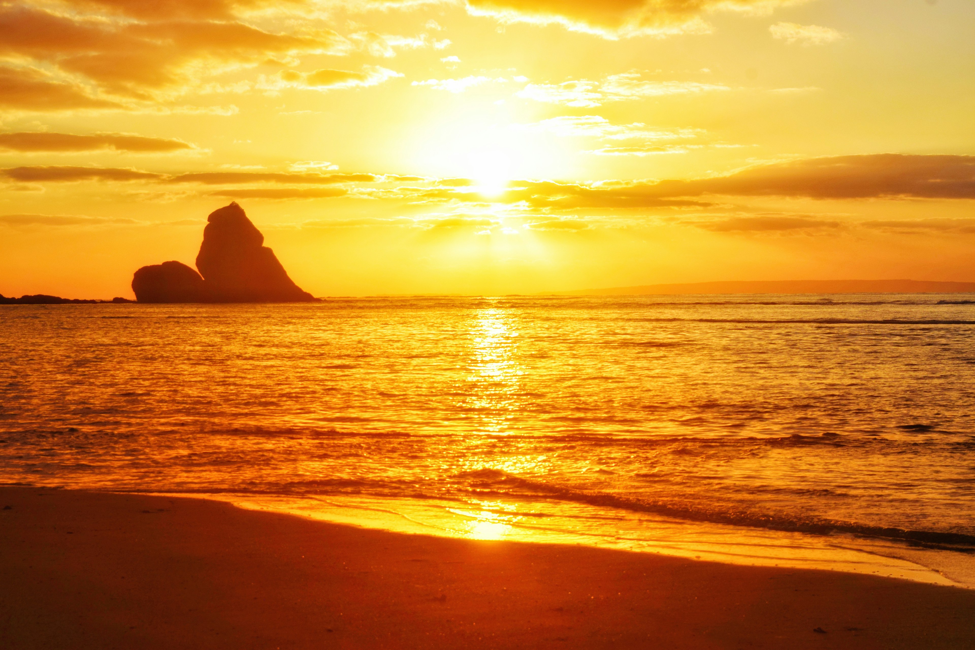 Beautiful sunset over the ocean with a rock formation