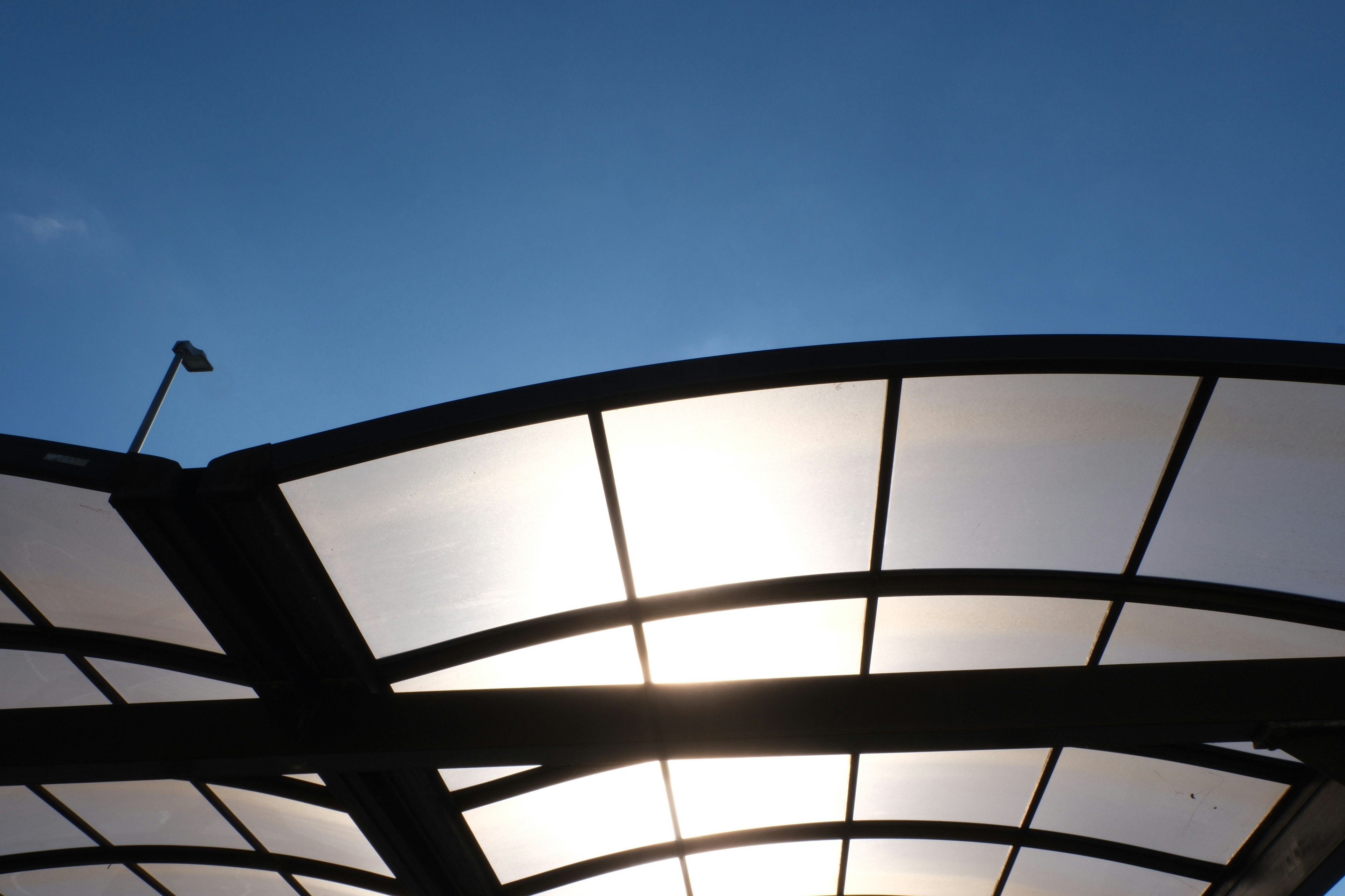 Silhouette d'une structure de toit moderne sous un ciel bleu